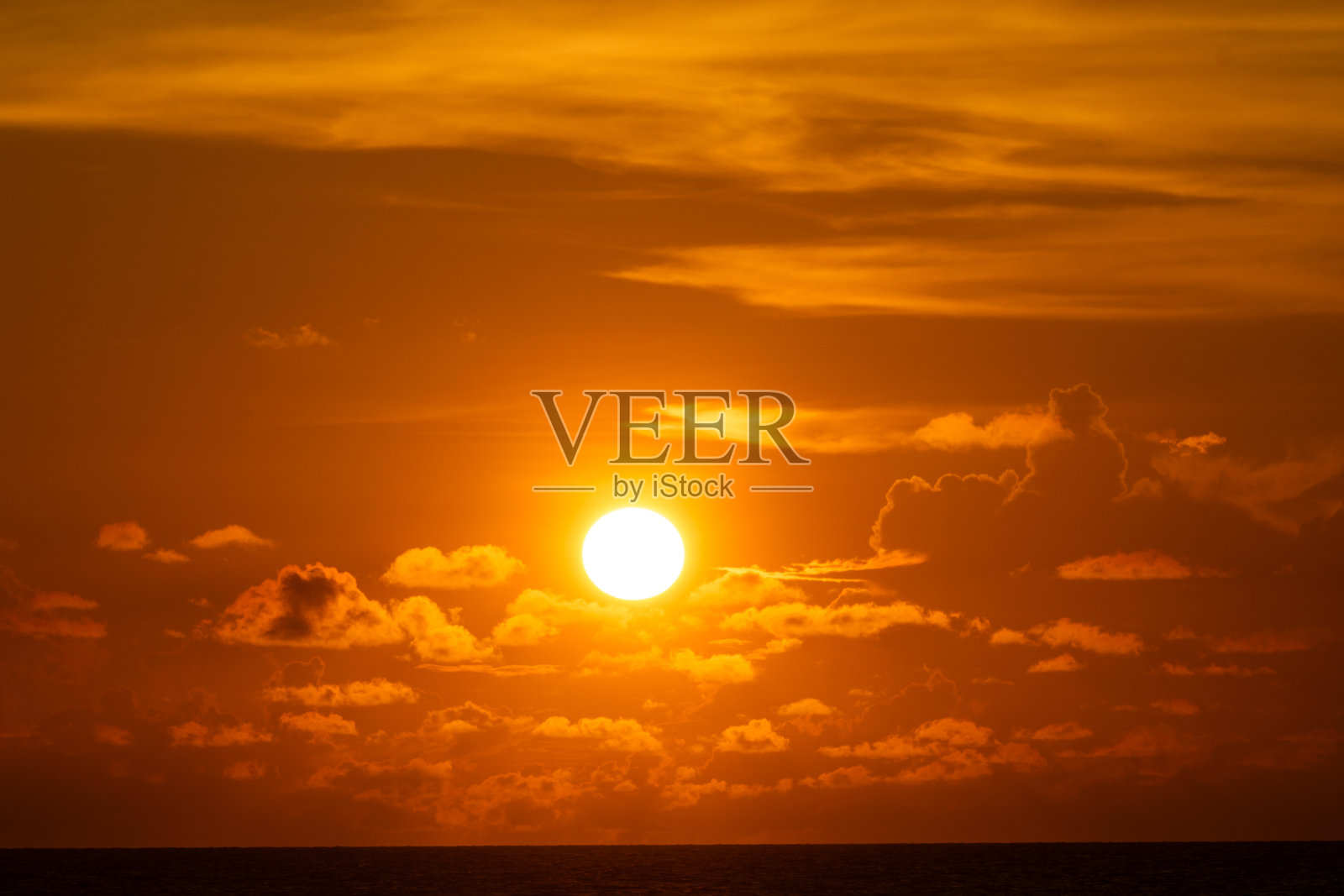 太阳在乌云后面，在日落时为周围地区创造了令人惊叹的光线照片摄影图片