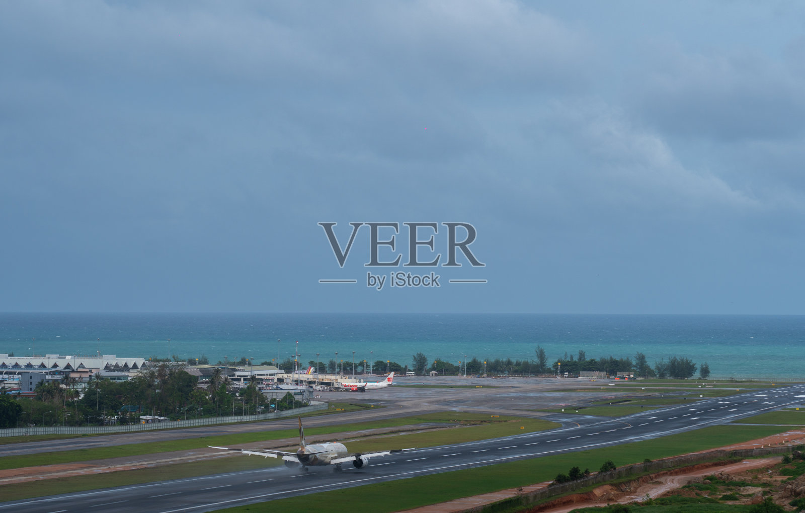 一架飞机降落在海滩和蓝天附近照片摄影图片