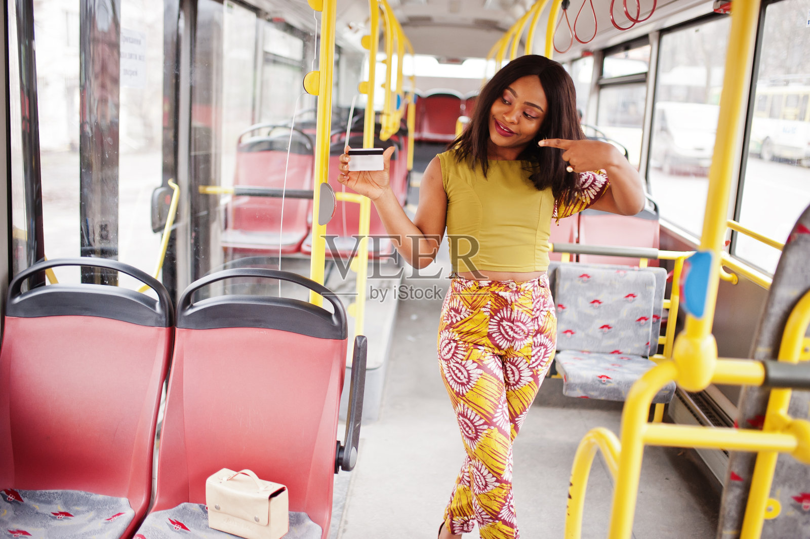 年轻时尚的非裔美国女性坐在公共汽车上。照片摄影图片