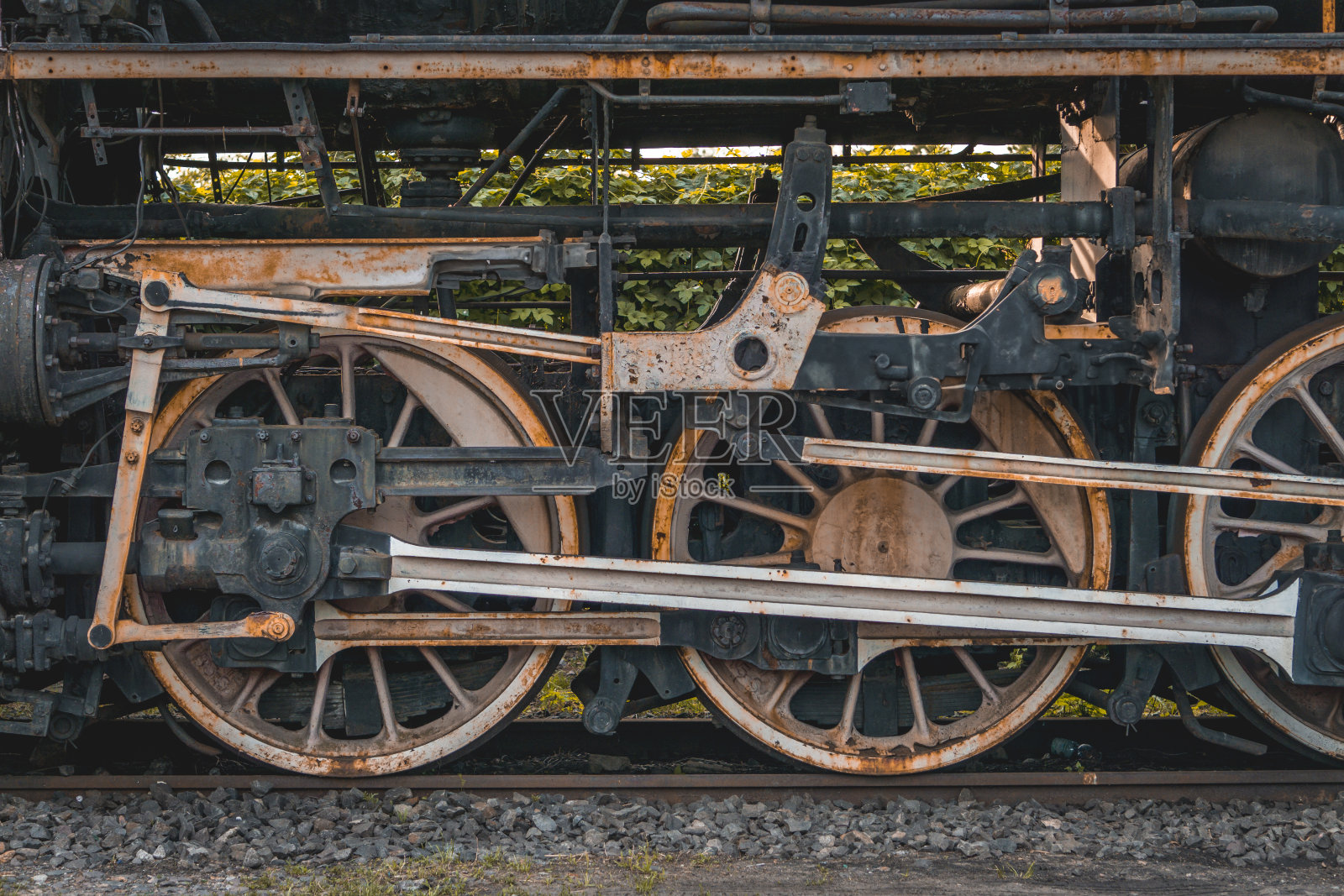 金属车轮和老式煤动力蒸汽机车的驱动机构。生锈的金属和钢铁照片摄影图片
