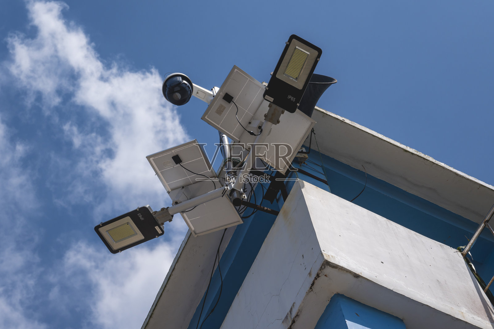 安装在灯塔结构屋檐上的太阳能LED灯。中午在阳光下充电。照片摄影图片