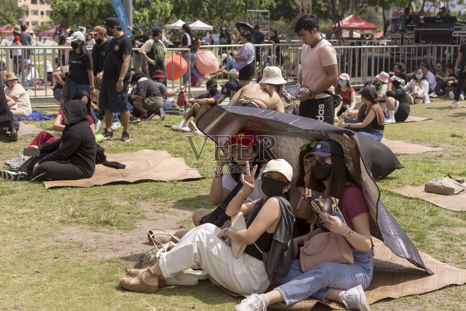 马卡蒂，马尼拉大都会，菲律宾——一群狂欢者躲在树荫下参加Bobapalooza音乐节。照片摄影图片
