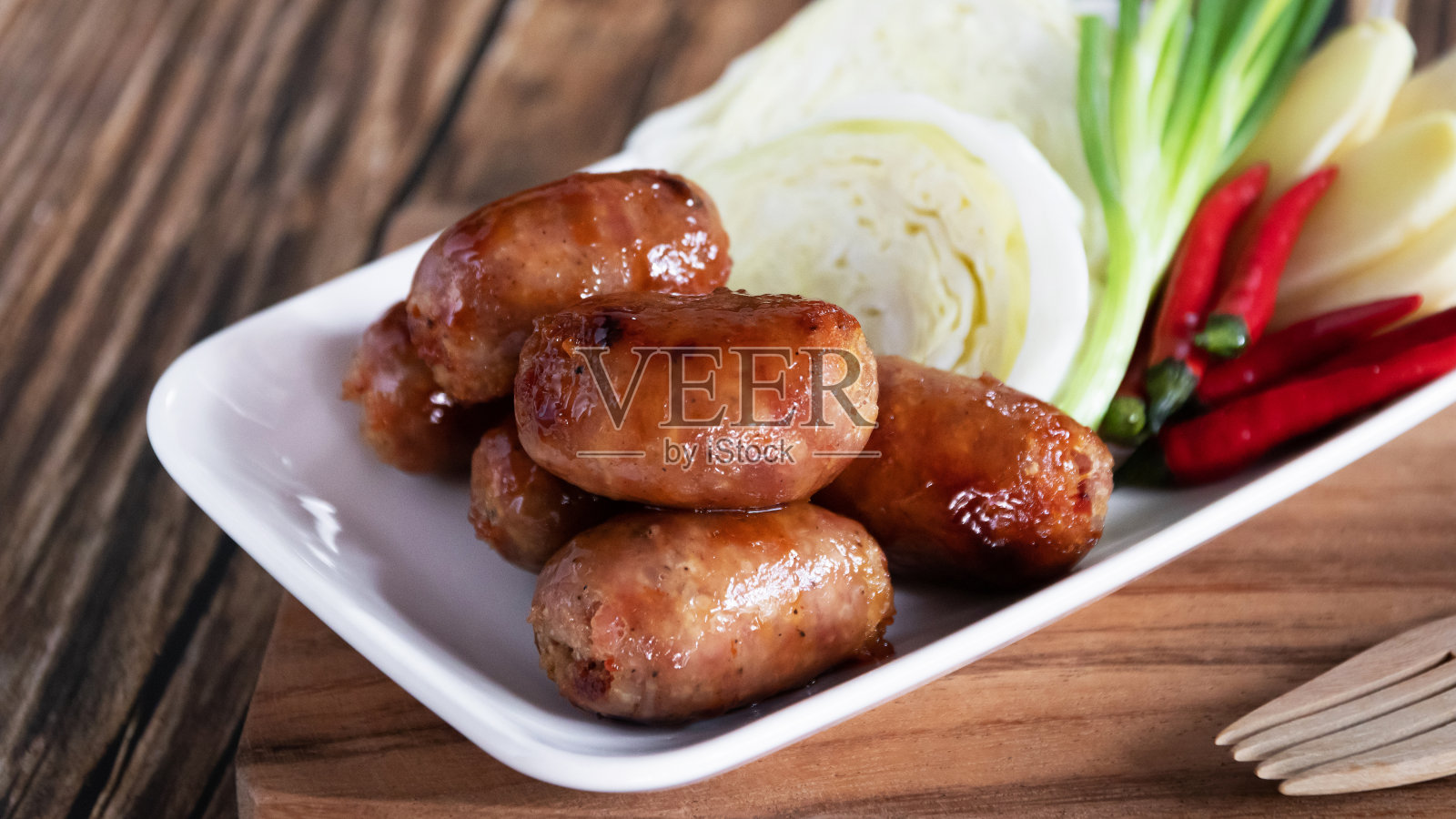 猪肉香肠是泰国很受欢迎的街头小吃。它们是用碎猪肉、大蒜和香料烤成的。照片摄影图片