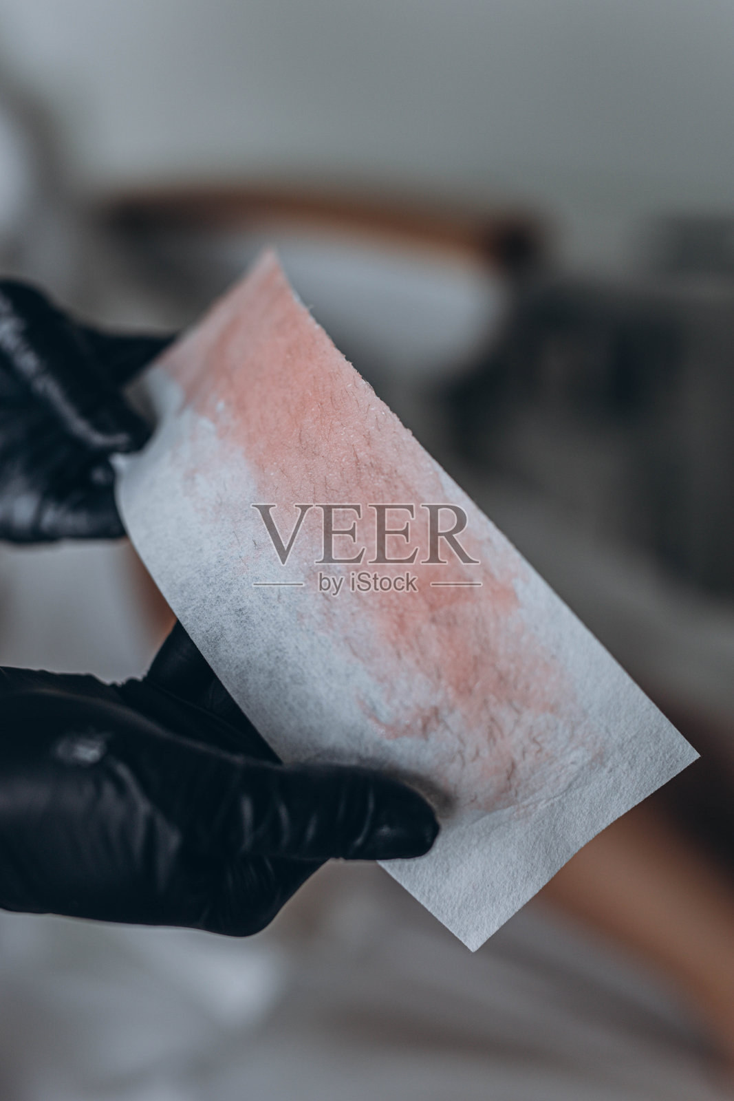 美容师在水疗中心用液体糖为年轻女子脱毛照片摄影图片