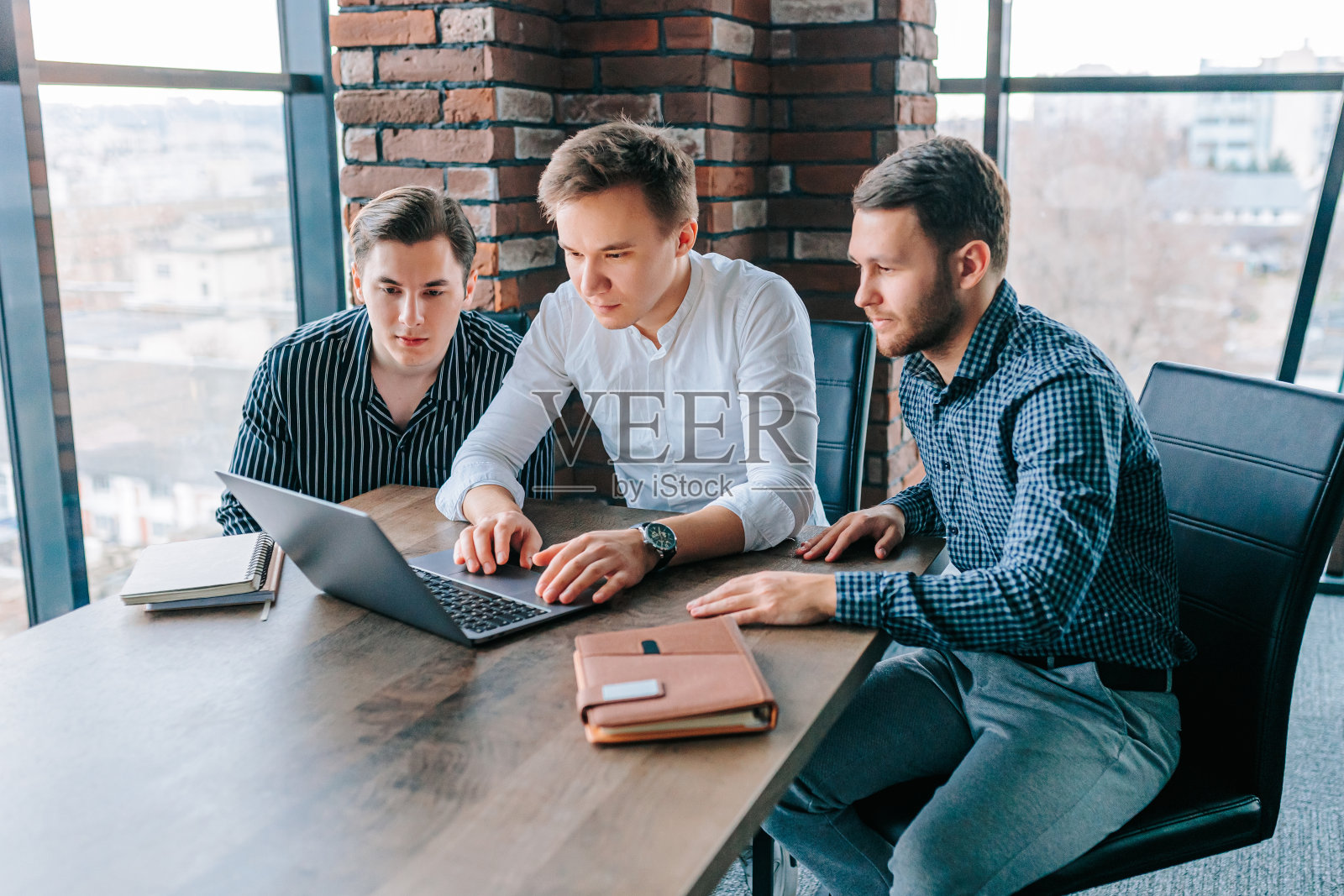 一队年轻的专业人士在他们的笔记本电脑上接受教练的指导照片摄影图片