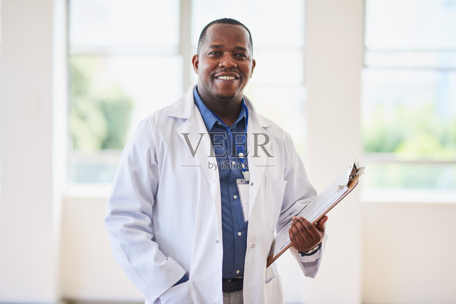 自信的非裔美国医生在现代医院设置拿着剪贴板照片摄影图片