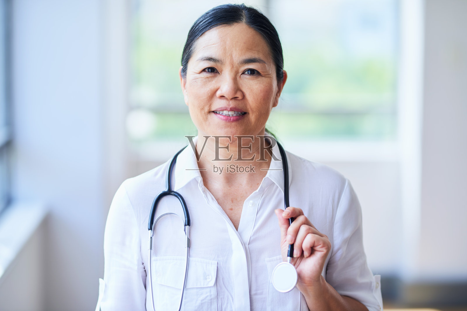 带着听诊器的自信女医生在医院里照片摄影图片