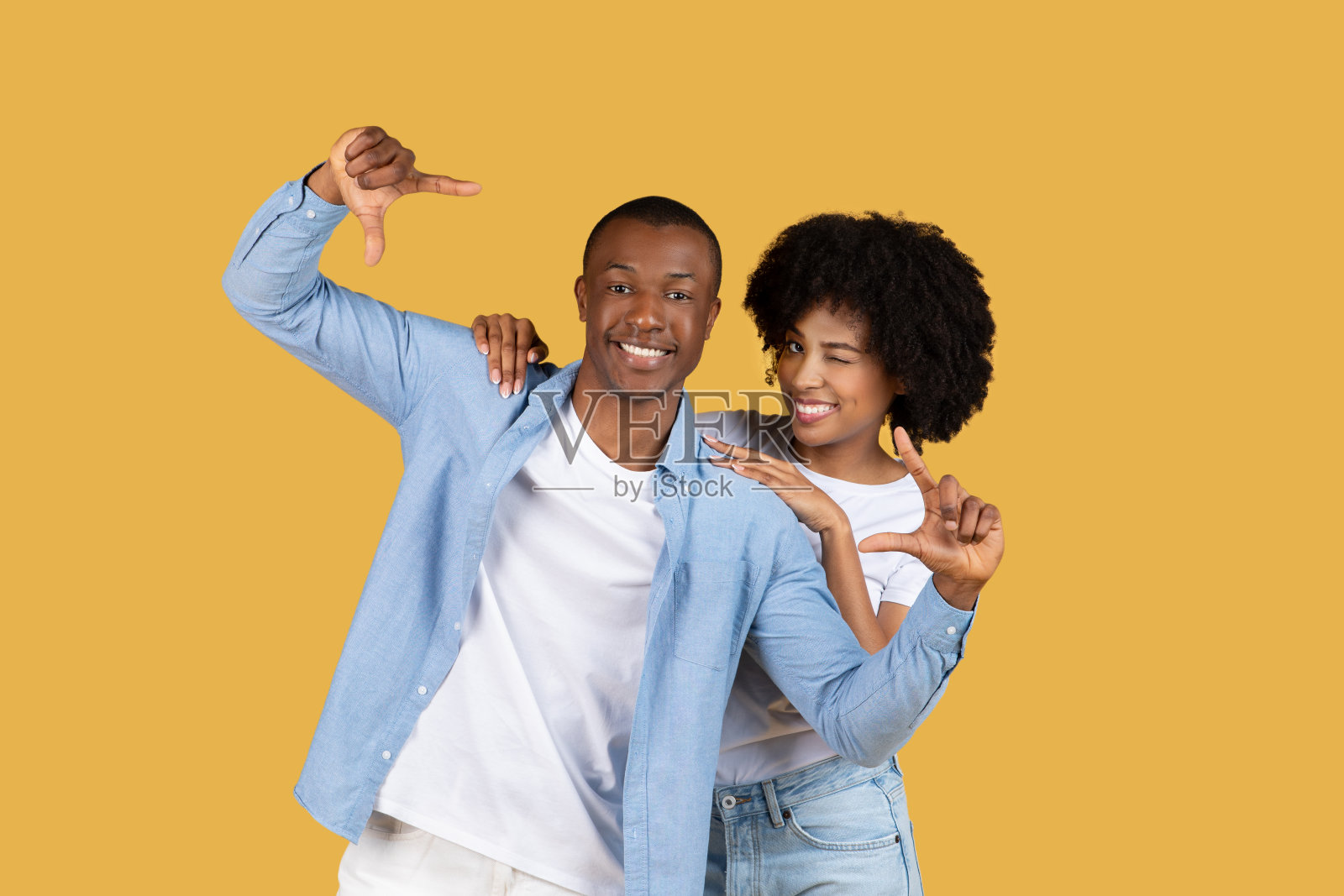 这对幸福的情侣在黄色上用拇指做手势照片摄影图片