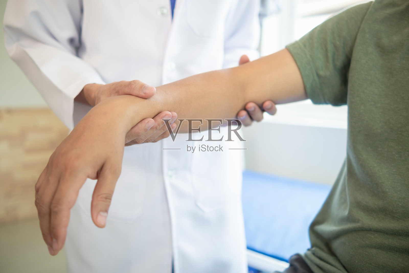 医生正在帮助一名肌肉受伤的病人活动肌肉，并希望通过持续的物理治疗使她恢复正常的日常生活。照片摄影图片