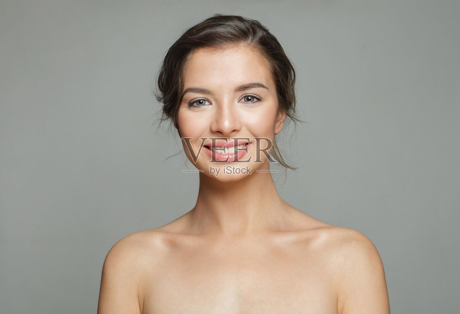 开朗健康的模特女人与美丽的皮肤和可爱的微笑在白色的背景，工作室肖像。面部护理，护肤和美容的概念照片摄影图片