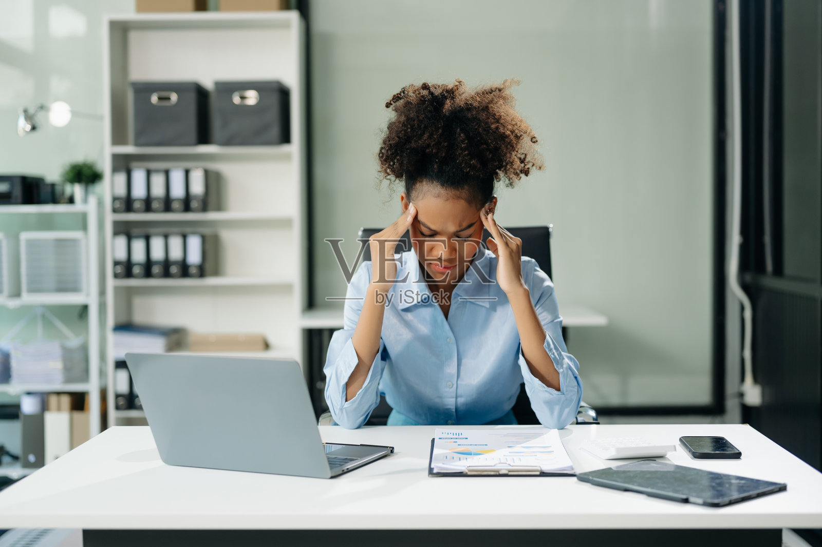 女性感到头痛。在笔记本电脑和平板电脑上工作的劳累过度的女商人金融家照片摄影图片