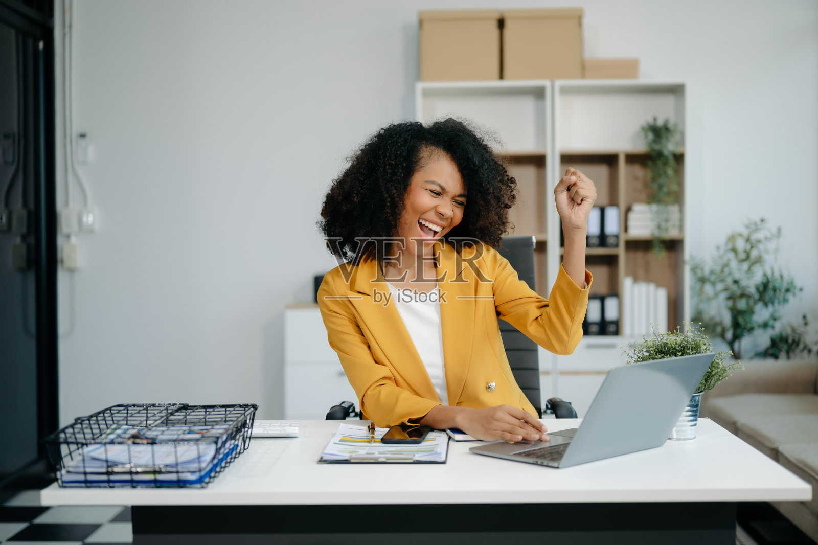 商务女性对她们在办公室用平板电脑、笔记本电脑和做笔记所做的工作感到高兴和快乐。照片摄影图片