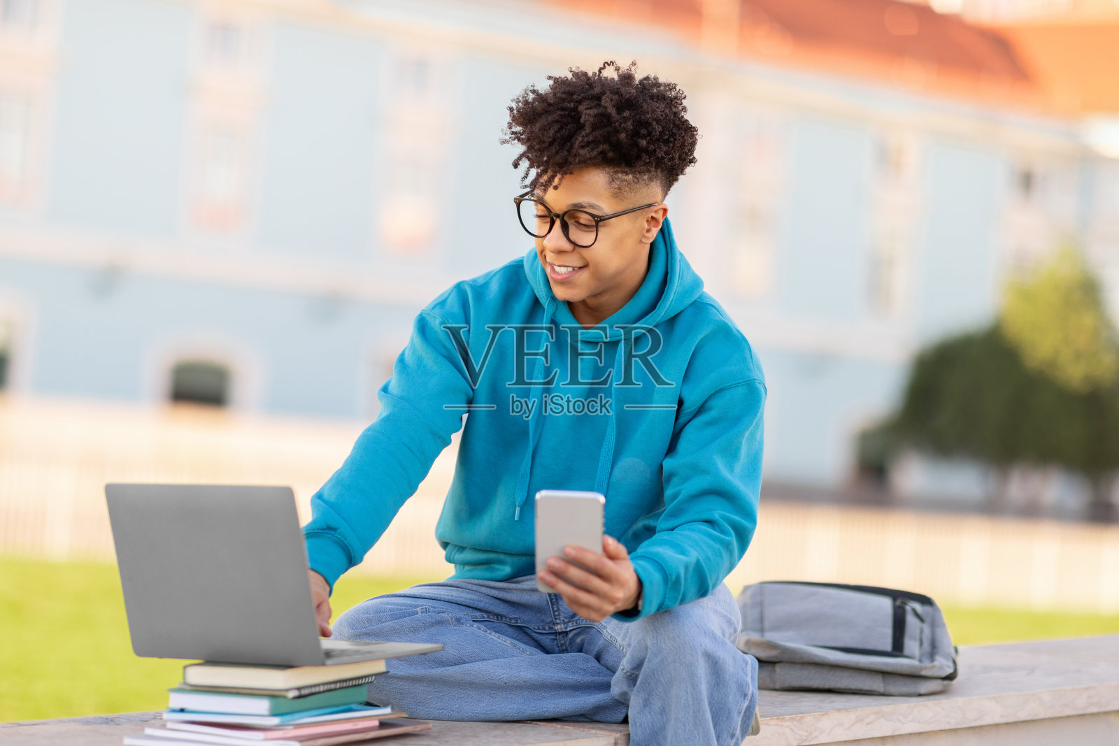 学生使用笔记本电脑和手机进行多任务处理照片摄影图片