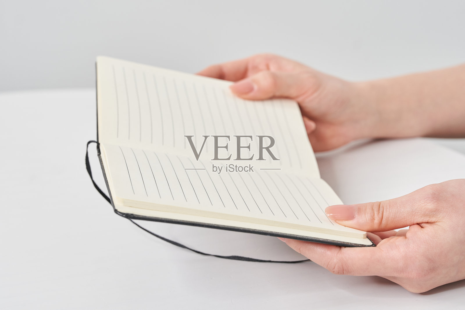 一个女人拿着记事本的手照片摄影图片