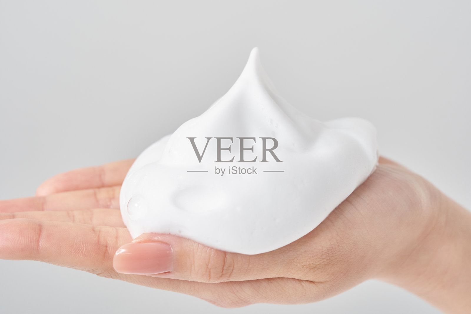 一个女人的手把一块泡沫放在她的手掌上照片摄影图片