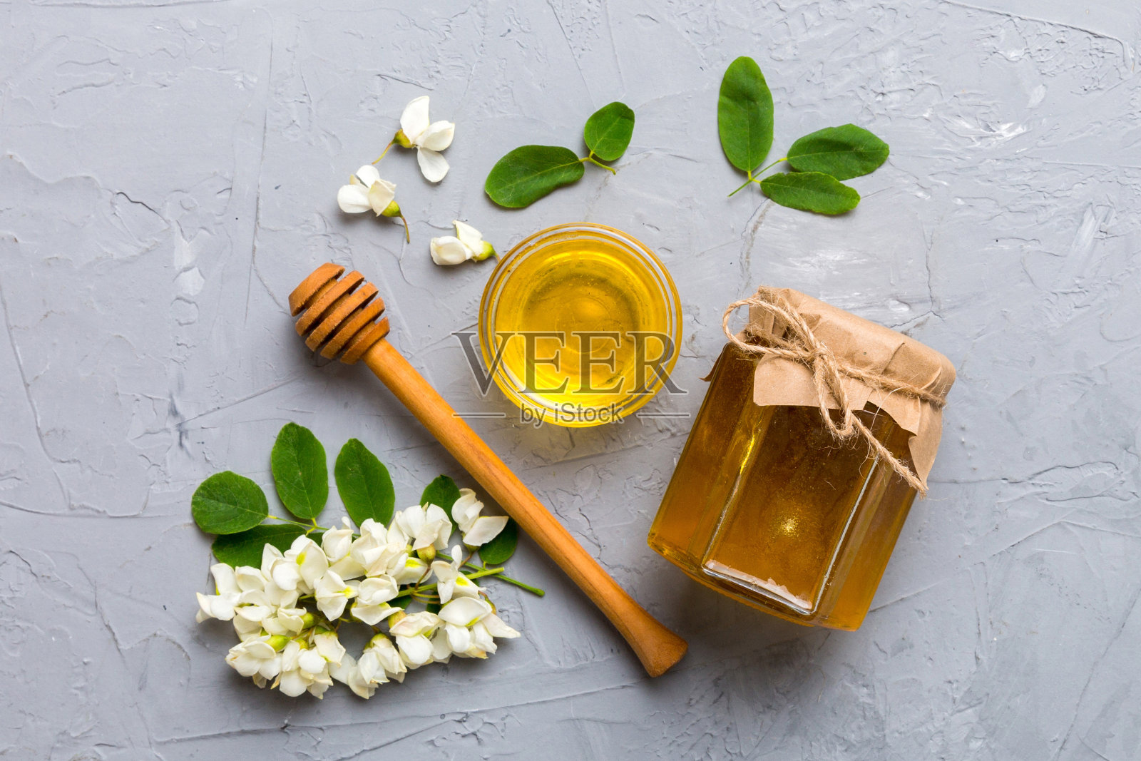 装有相思花和叶子的蜜罐。新鲜蜂蜜顶视图平躺照片摄影图片