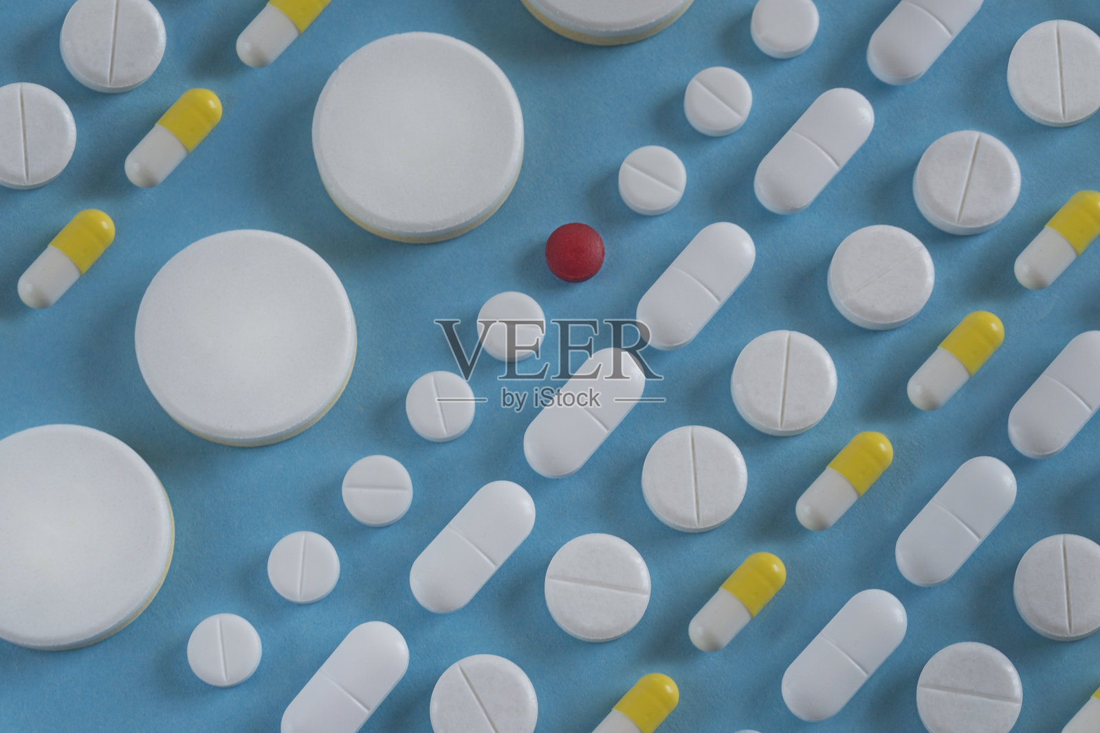 蓝色背景上一排排白色药片。医学的概念照片摄影图片