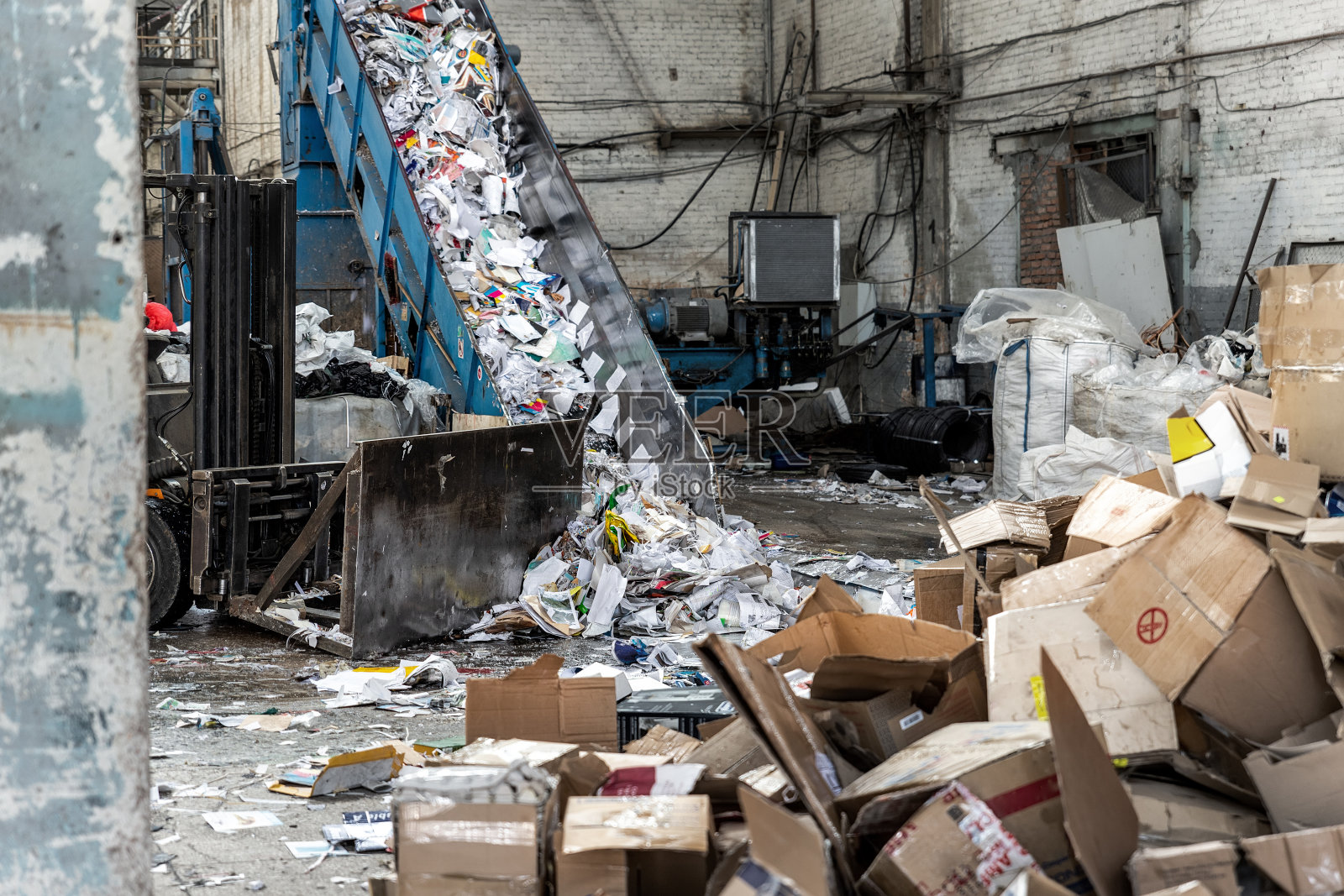 将废纸厂传送带切碎，以回收包装纸、垃圾和纸板，以对抗工业厂房或工厂收集的回收和再利用的纸箱。可持续发展的照片摄影图片