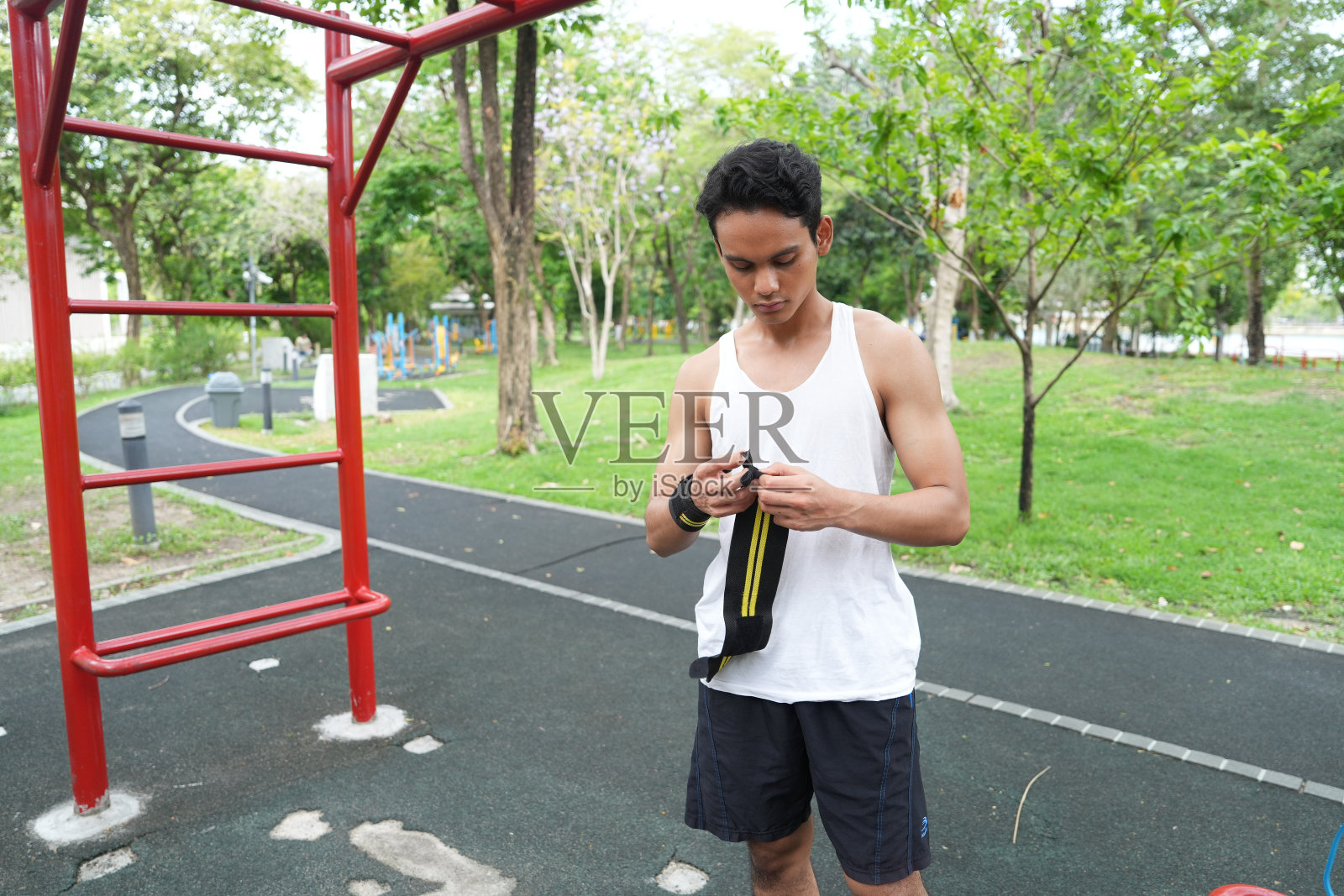 亚洲男子练习体操做体操杠和箍练习伸展和休息运动。照片摄影图片