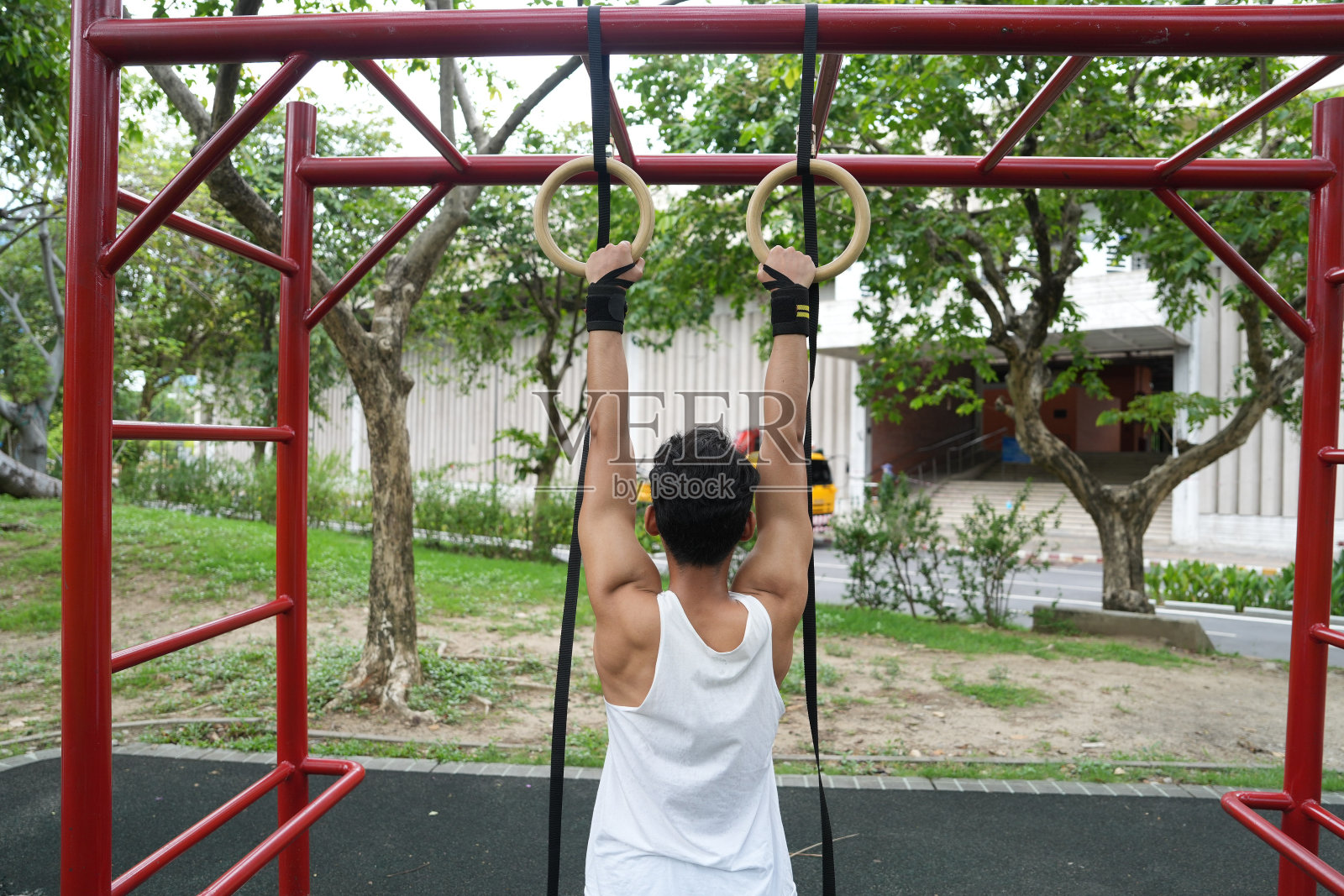 亚洲男子练习体操做体操杠和箍练习伸展和休息运动。照片摄影图片