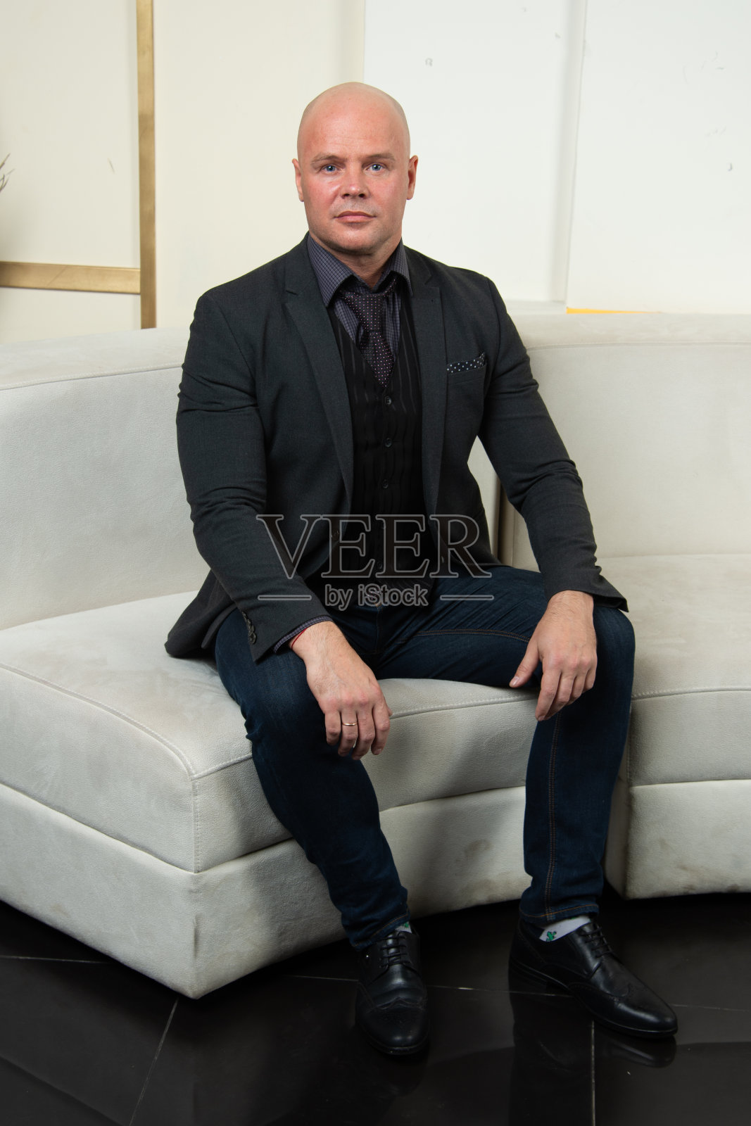 一个成年秃顶男人在摄影棚里摆姿势。照片摄影图片