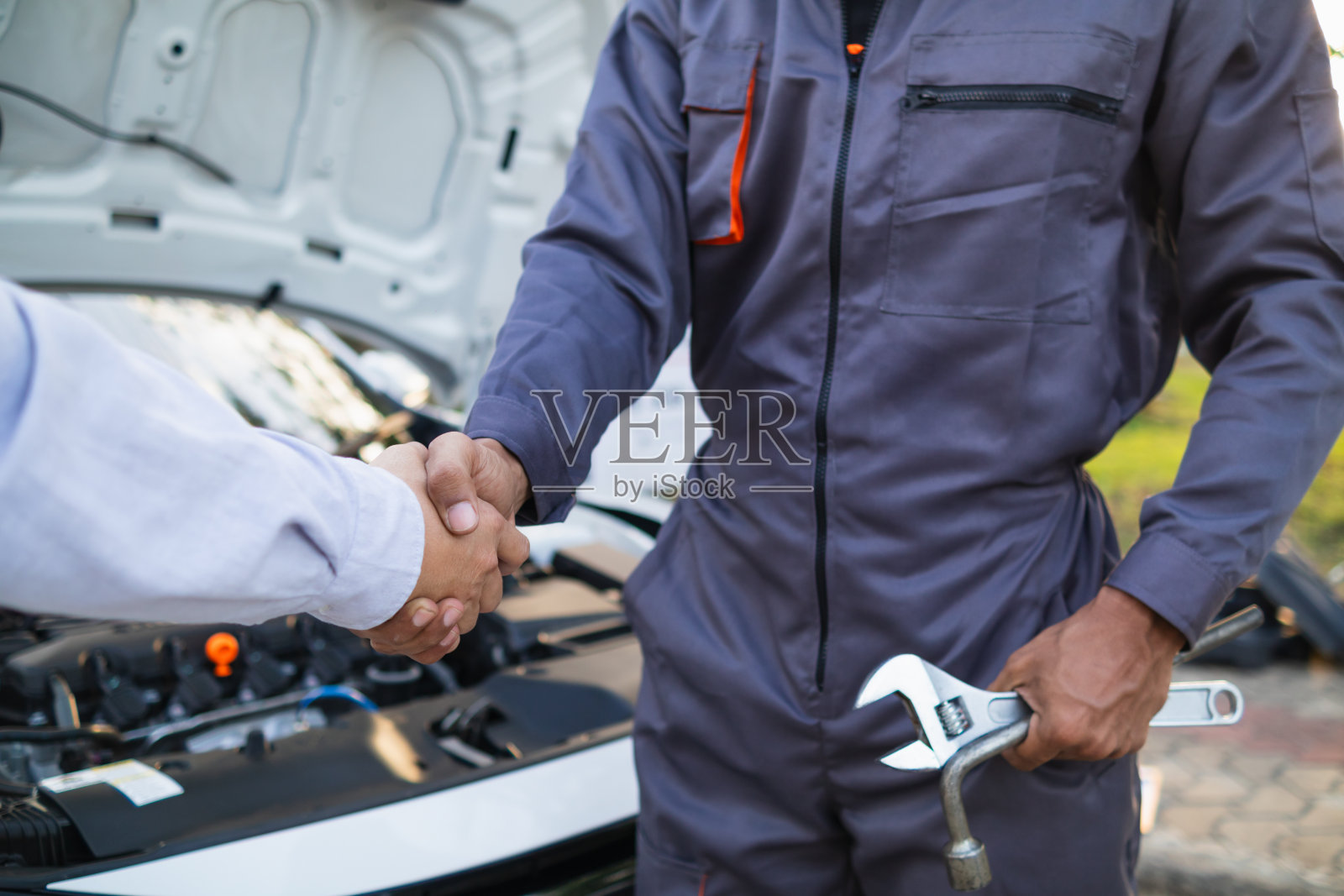 服务中心的技术人员检查并协助客户在旅行中遇到问题的汽车，为选择在服务中心购买汽车的客户建立信心，并迅速得到帮助照片摄影图片