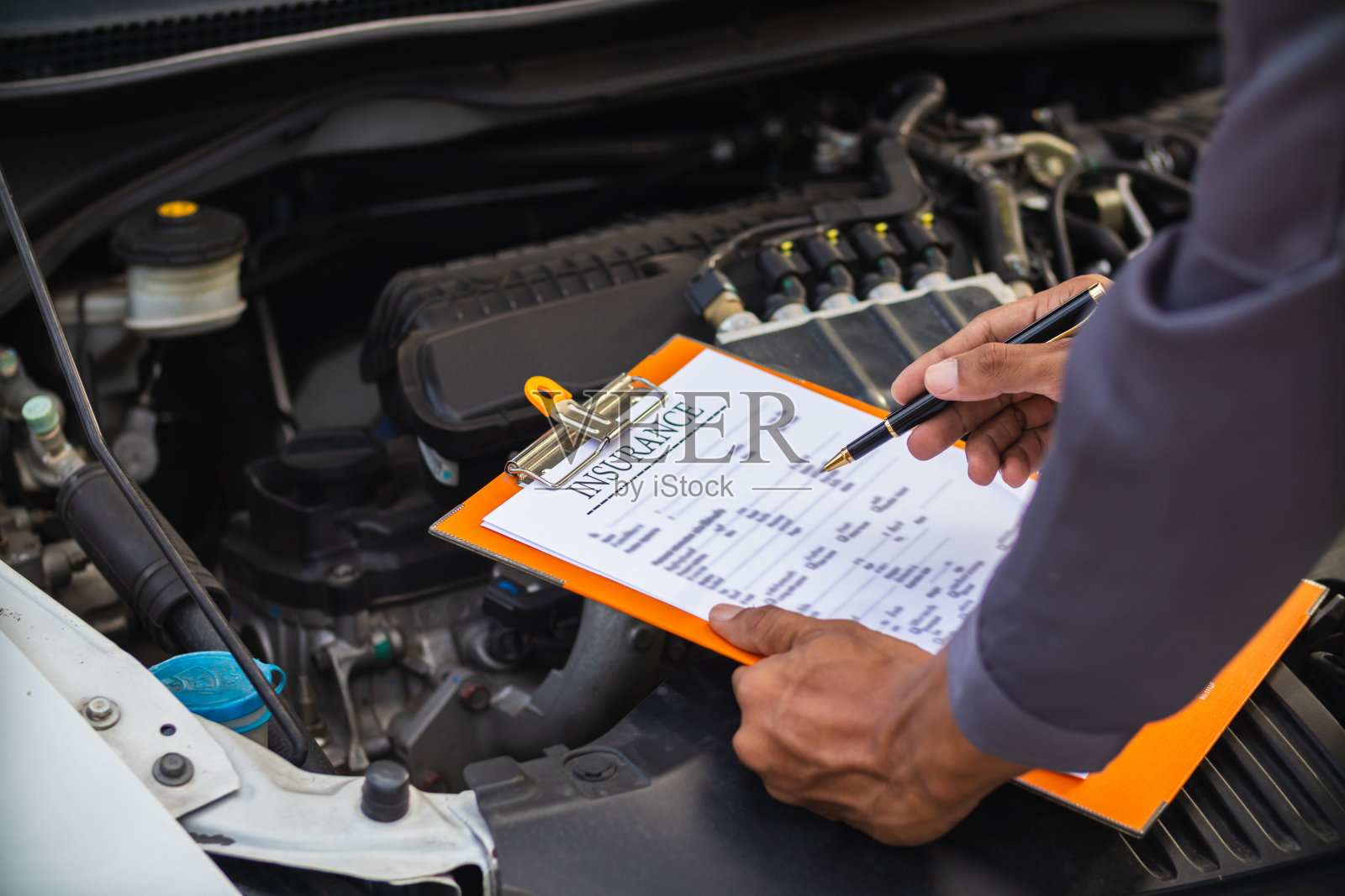 汽车维修中心的机械师正在检查汽车和发动机的状况，确保它们随时可以使用，并按照中心的保修要求处于完美状态。定期检查车辆，确保行车安全。照片摄影图片