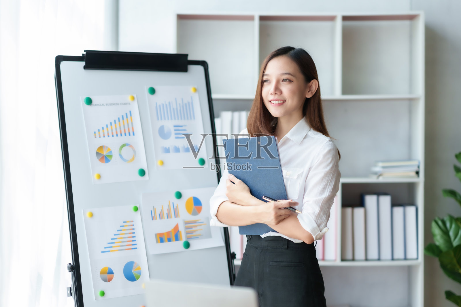 美丽自信的亚洲女商人，双臂交叉在办公室，在工作中思考新的想法。照片摄影图片