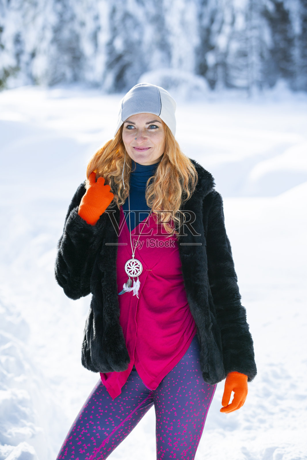 快乐的美丽女人在冬天的雪山照片摄影图片