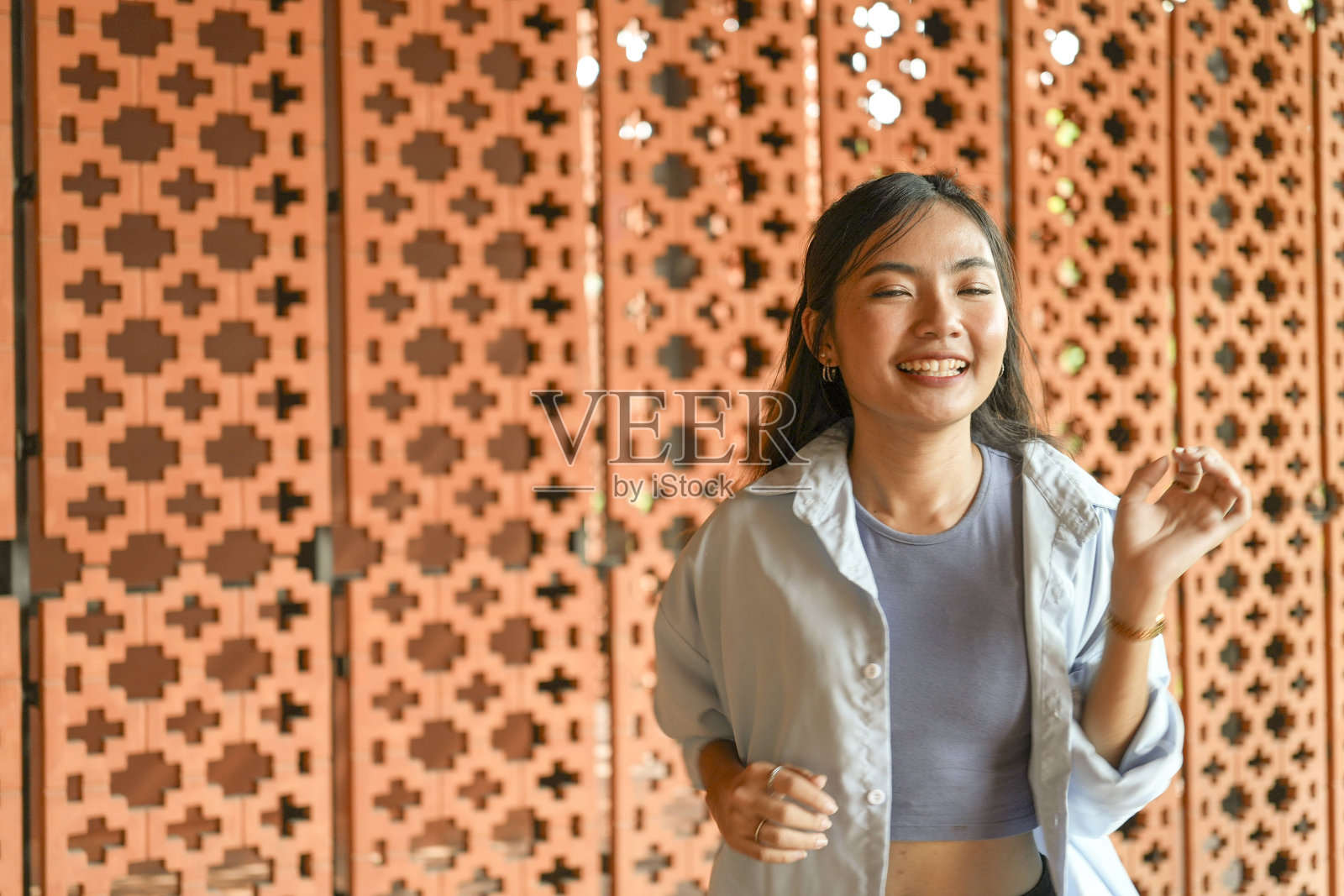 年轻的东南亚女性在花园和城市的中心以充满活力和时尚的方式练习嘻哈和其他自由式舞蹈动作。欢快地伴随着歌曲的节奏照片摄影图片