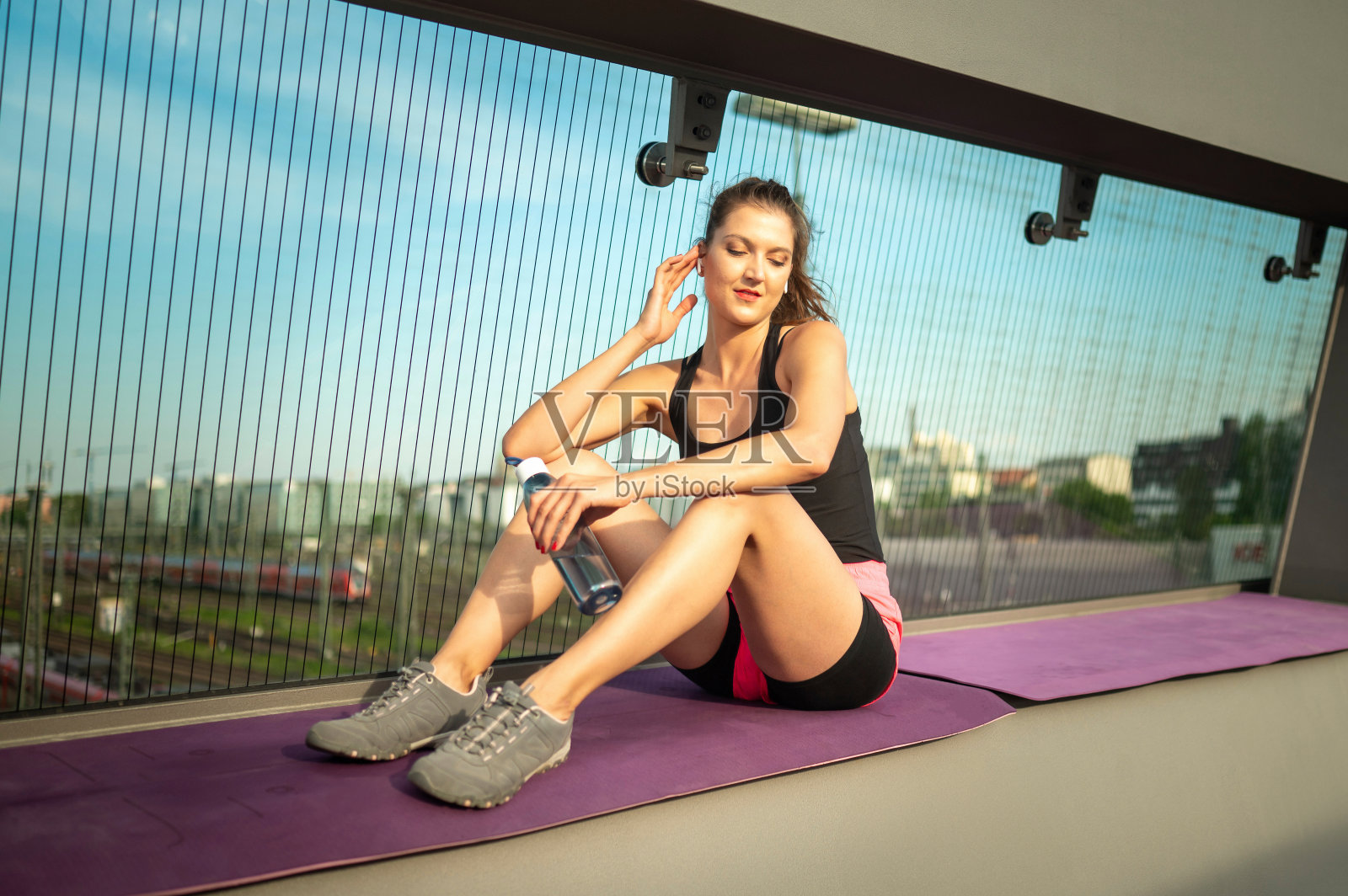 年轻的女运动员在一座现代建筑桥上训练。照片摄影图片