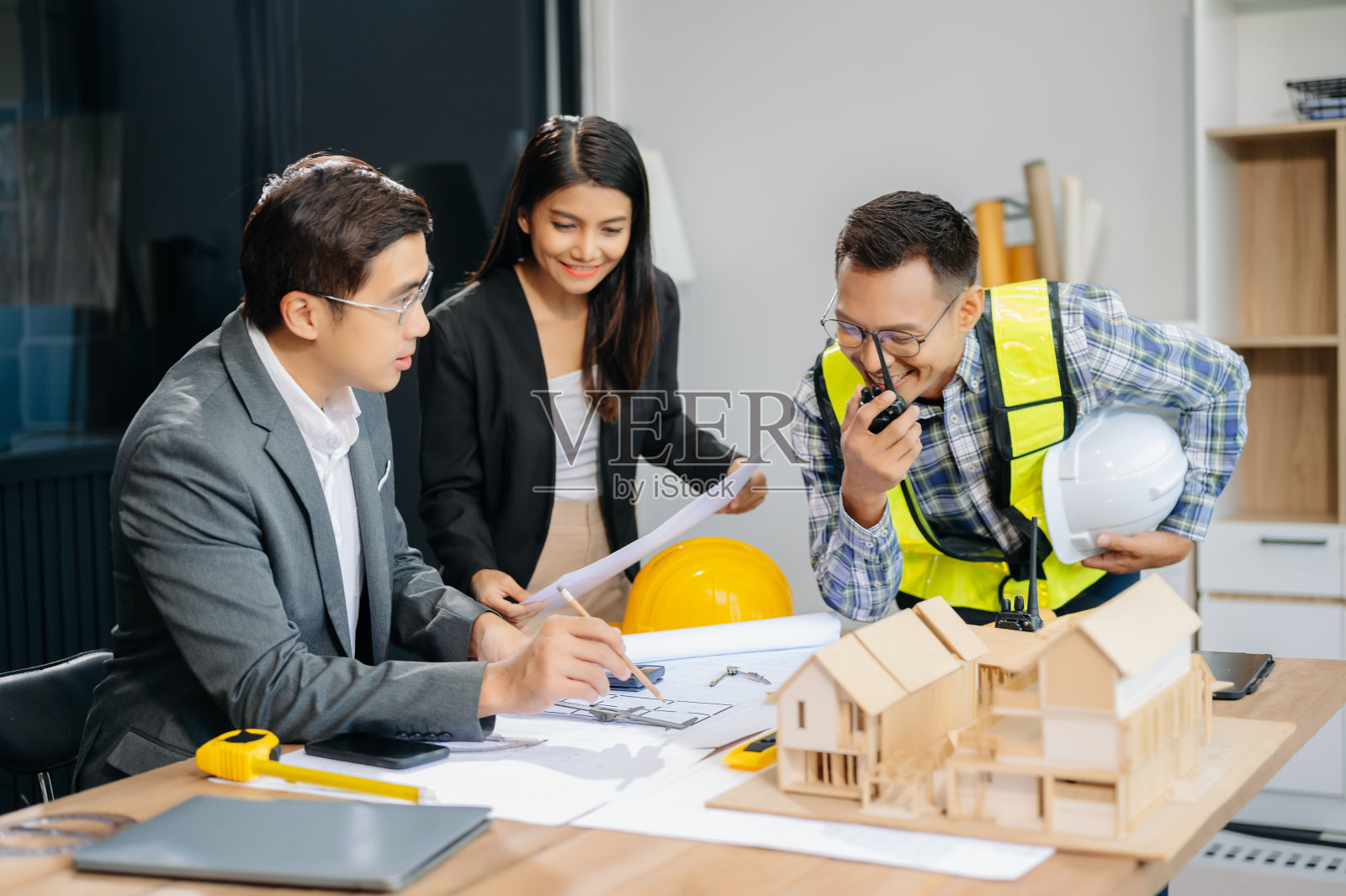 工程师团队开会一起工作，戴着工人头盔和安全帽，在建筑项目现场制作样板房。亚洲行业专业团队照片摄影图片