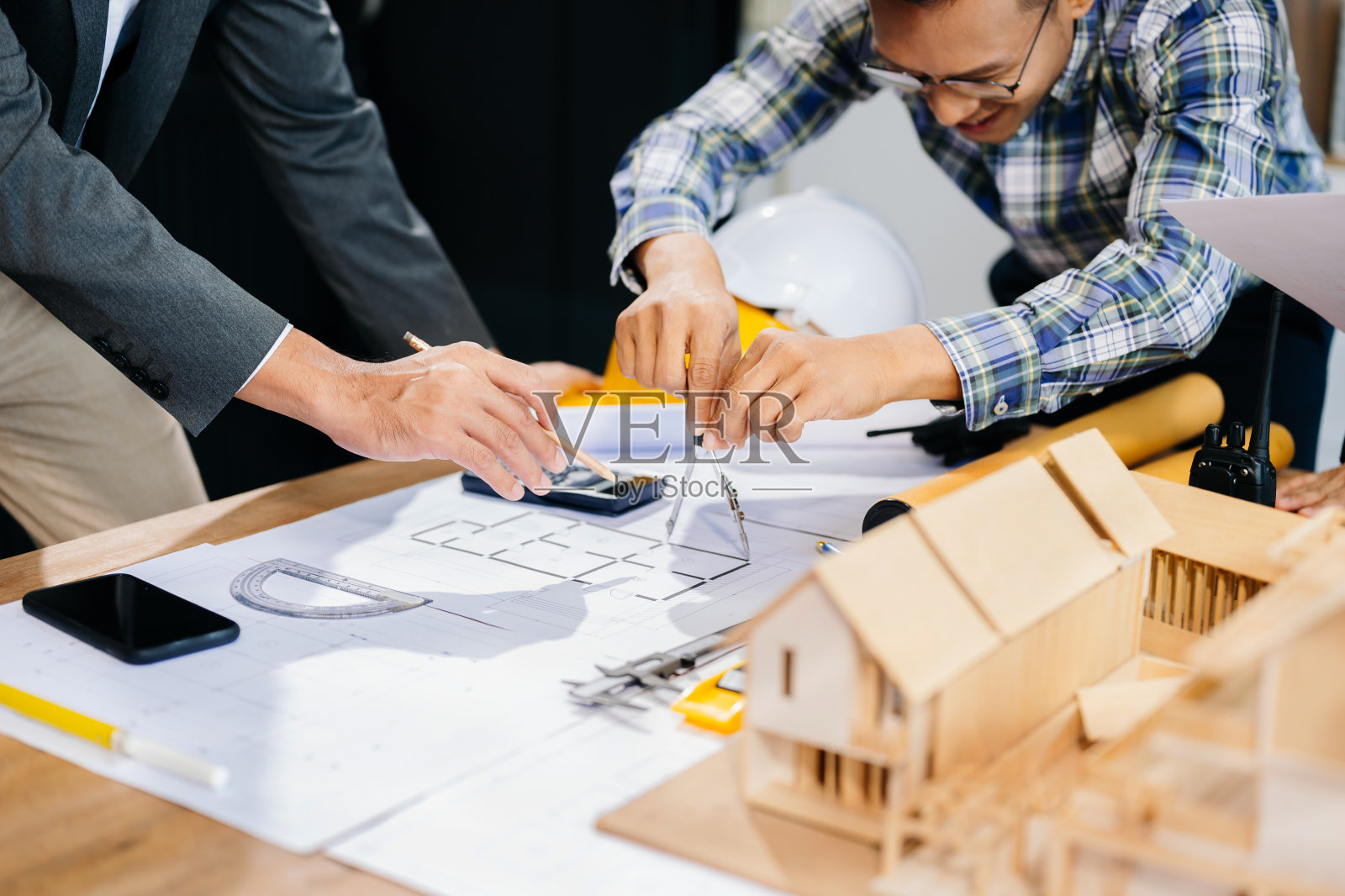 工程师团队开会一起工作，戴着工人头盔和安全帽，在建筑项目现场制作样板房。亚洲行业专业团队照片摄影图片