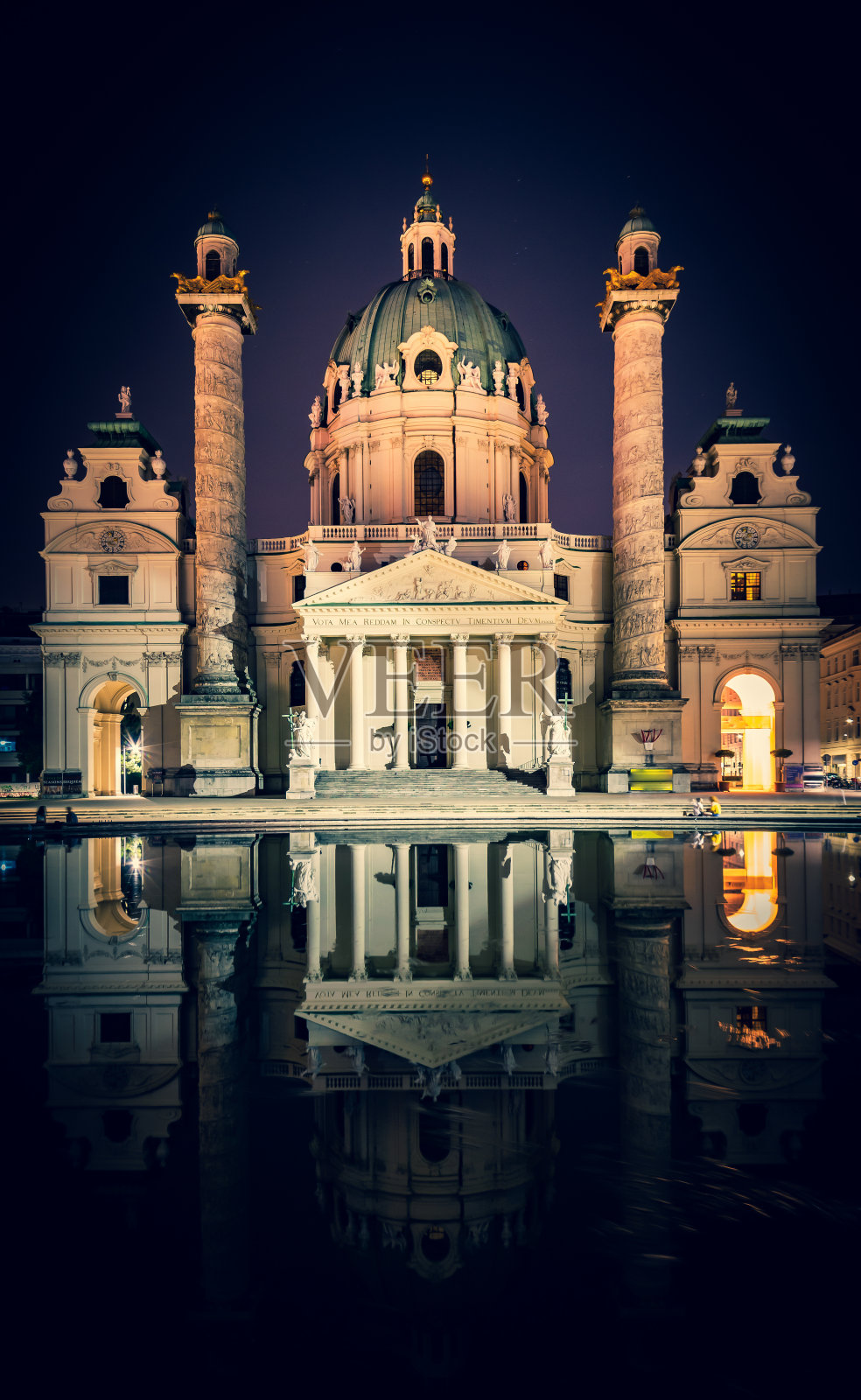 奥地利，维也纳——2022年6月15日:卡尔斯基什教堂和它在夜晚的倒影，游客们坐在附近。旅游及历史建筑照片摄影图片