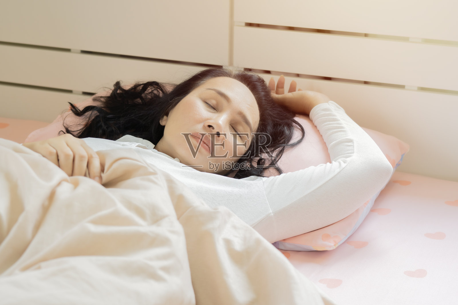 宁静宁静美丽的女士穿着睡衣躺在舒适的白色床上柔软的枕头放松地睡觉。照片摄影图片