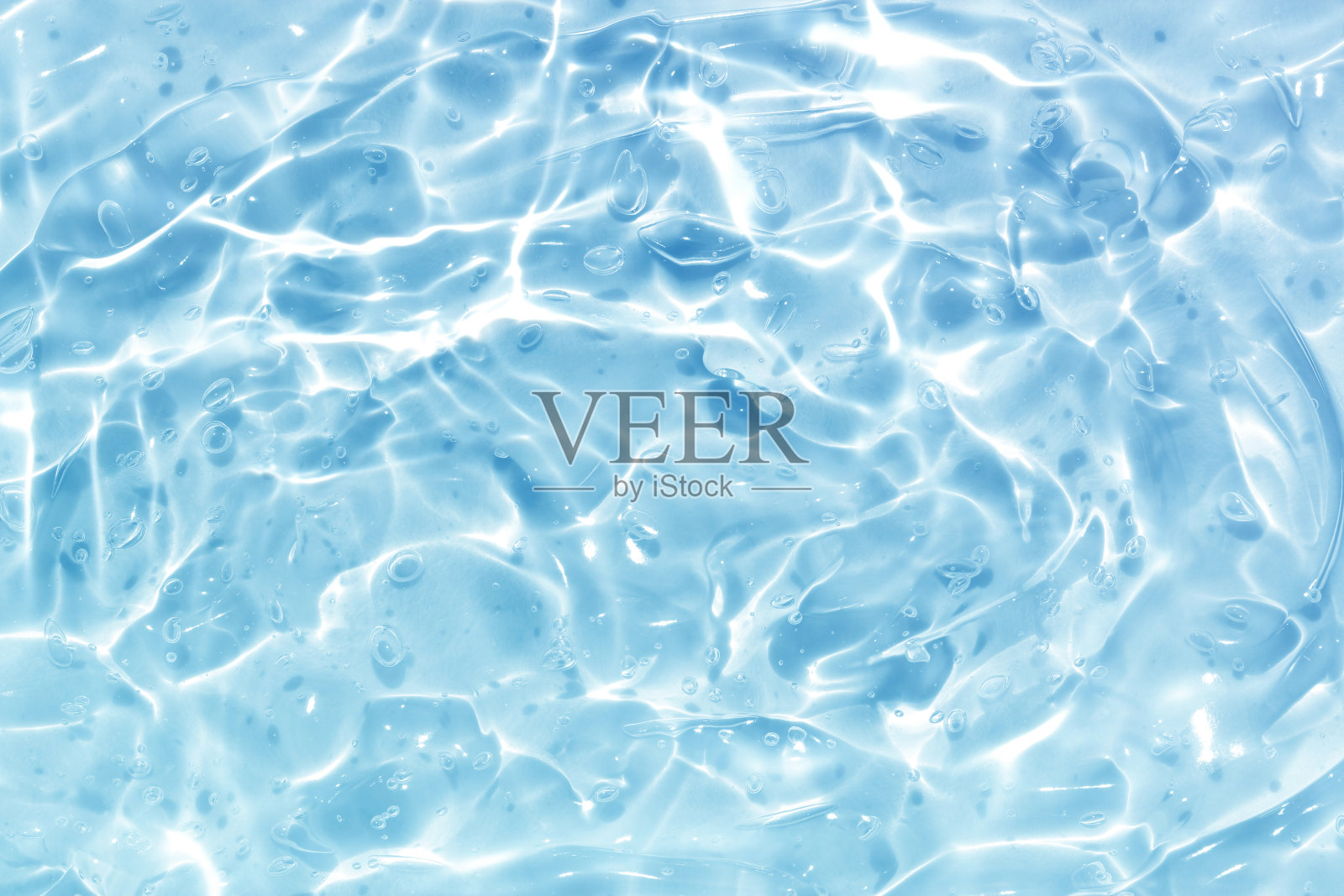 湛蓝的水波抽象。自然波纹和泡沫纹理。凝胶肥皂。背景摄影。照片摄影图片