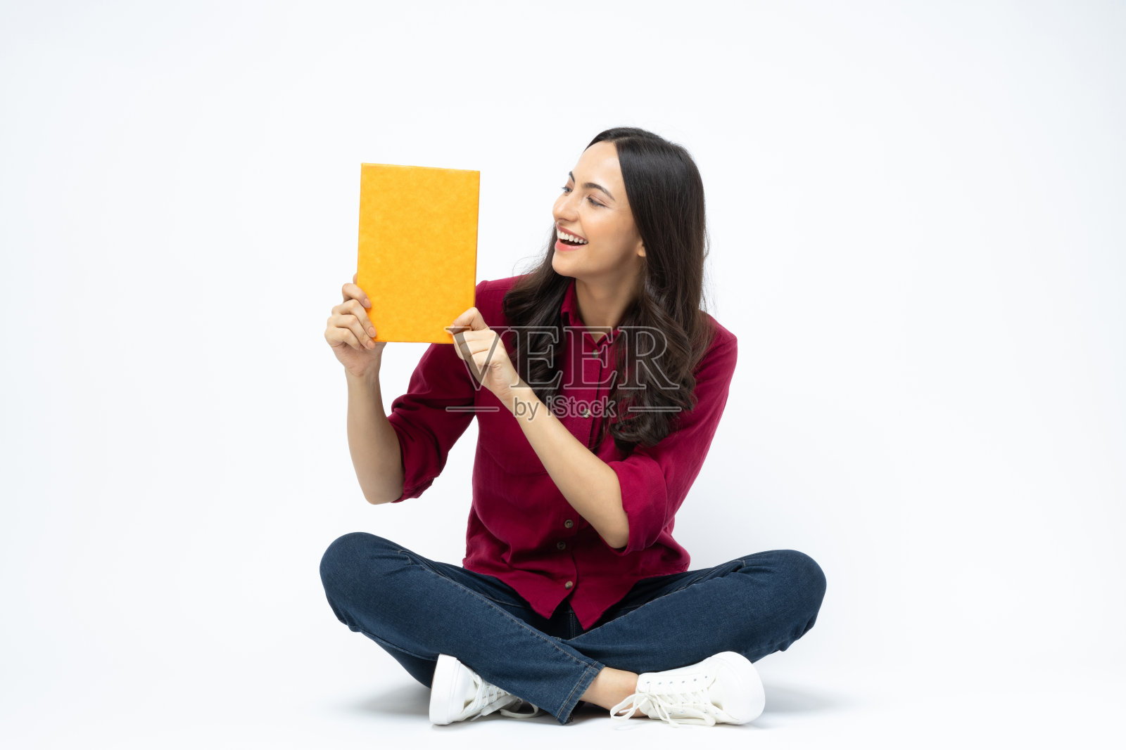 漂亮漂亮的女士的照片坐在地板上拿着文学书阅读最令人兴奋的凉爽时刻穿休闲衬衫牛仔裤孤立的白色背景股票照片照片摄影图片