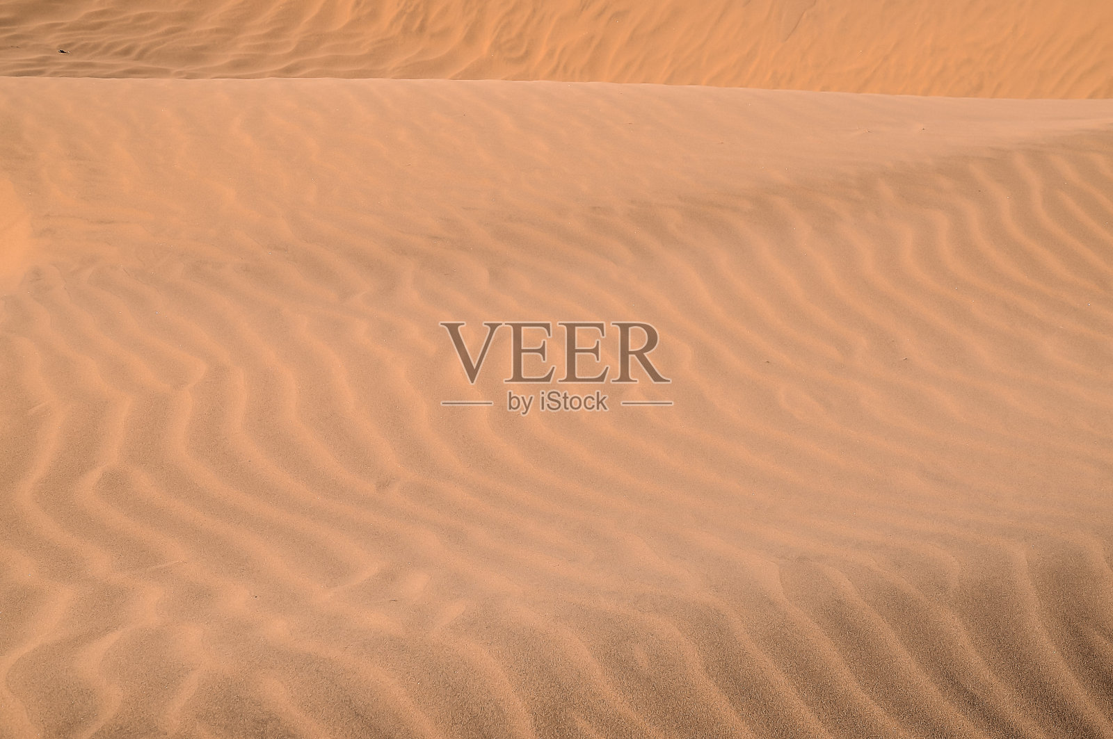 沙子是棕色的，有波浪状的纹理照片摄影图片