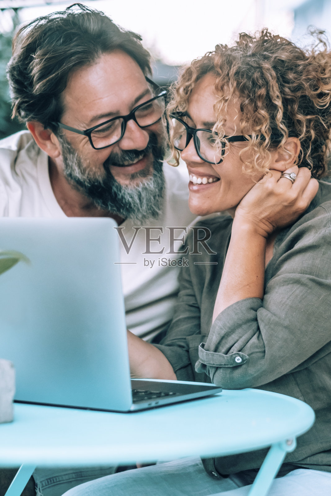 人们一起使用电脑与爱和友谊户外花园的家。快乐的现代生活方式与网络连接。男人和女人在社交媒体上微笑着，亲密无间。夫妻用笔记本电脑照片摄影图片