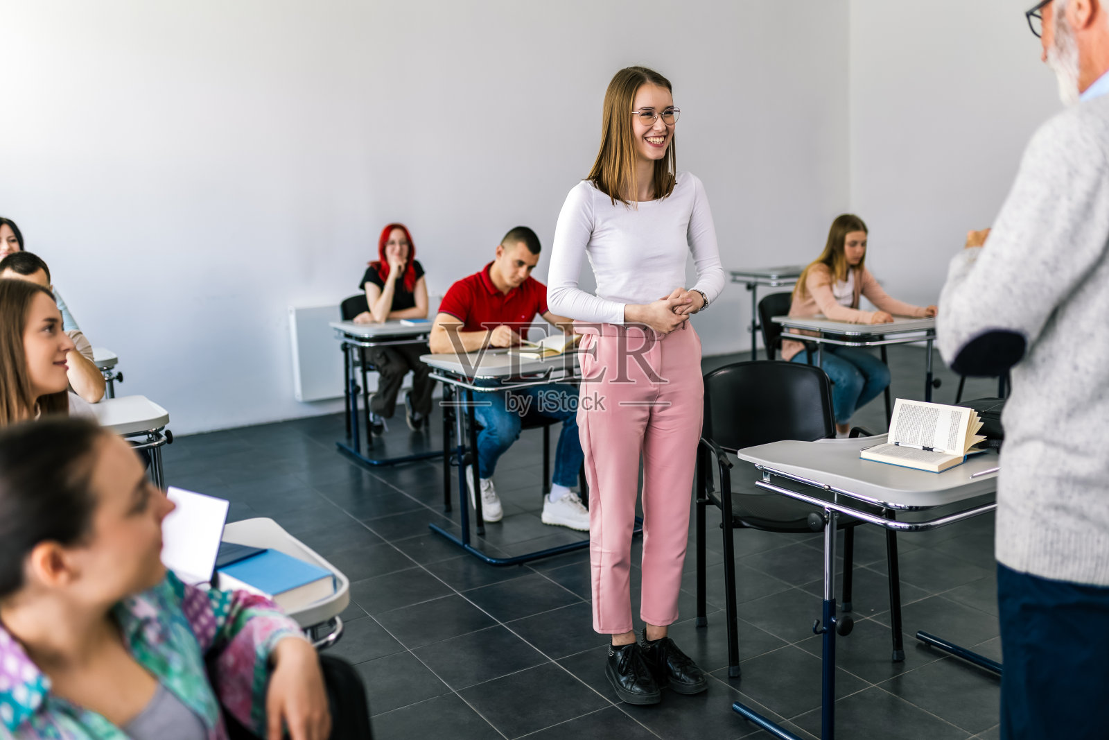 学生站在课桌前照片摄影图片