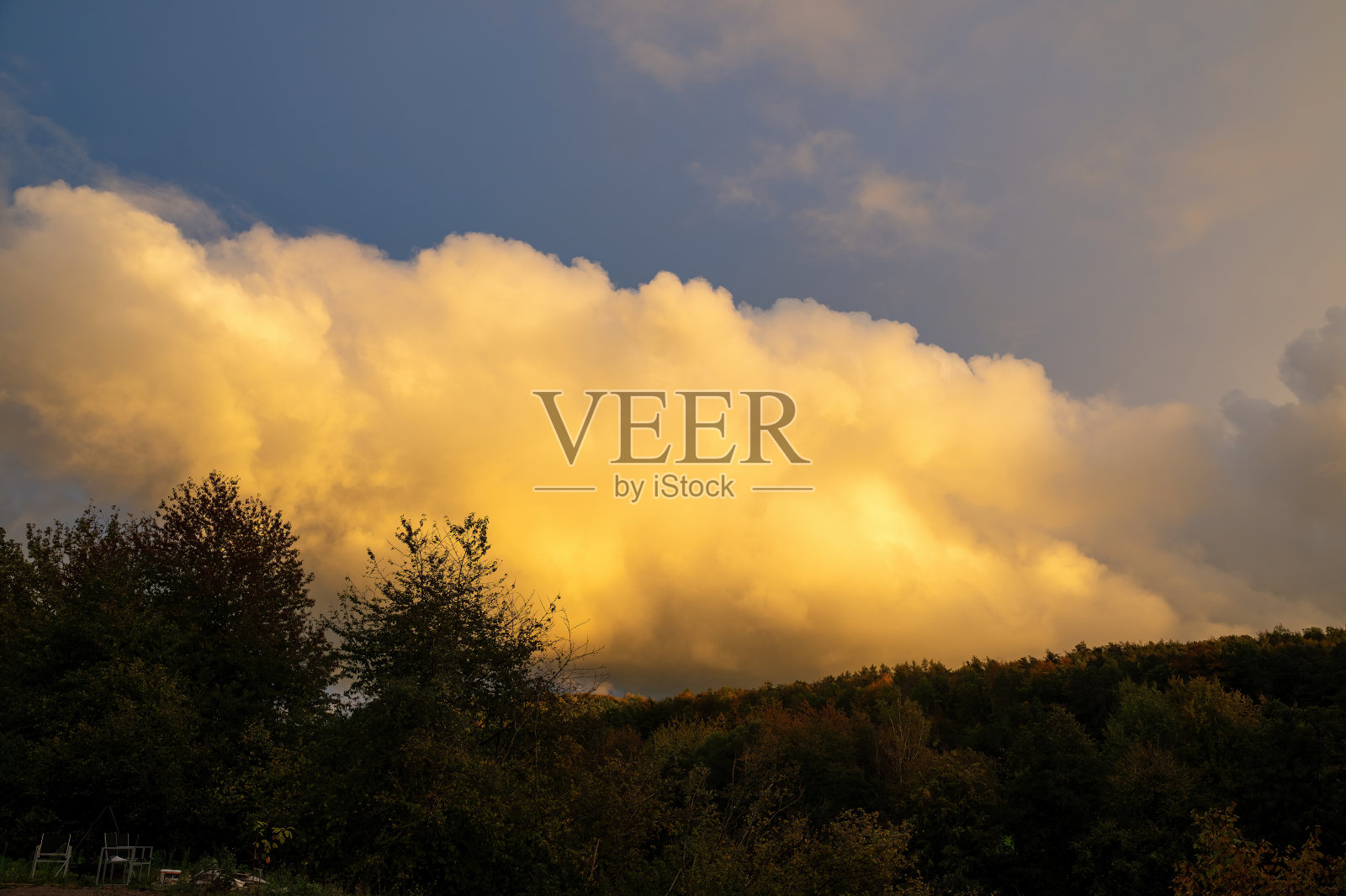 晚霞里的大云笼罩着绿色的森林照片摄影图片