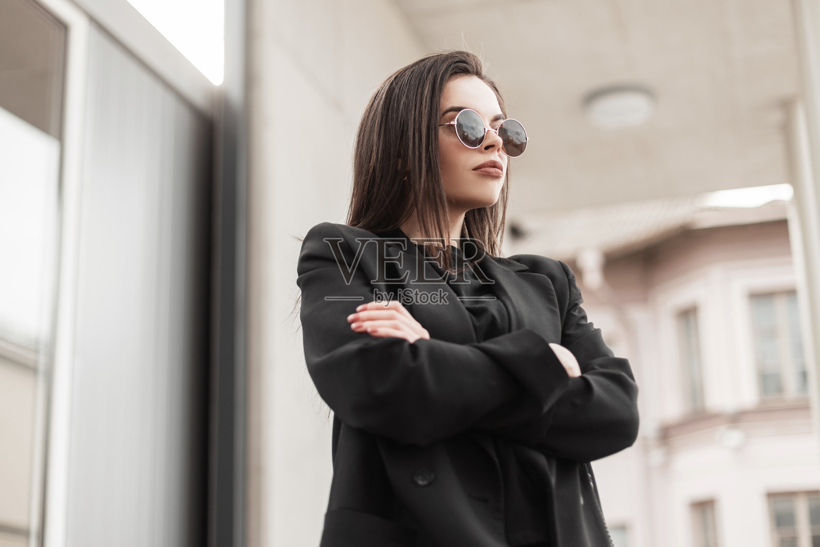 新鲜的肖像性感美丽的年轻女子戴着时髦的太阳镜，穿着黑色复古西装，穿着时尚的t恤，在城市的现代墙附近。迷人的美国女孩时尚模特在时尚的穿着在街上照片摄影图片