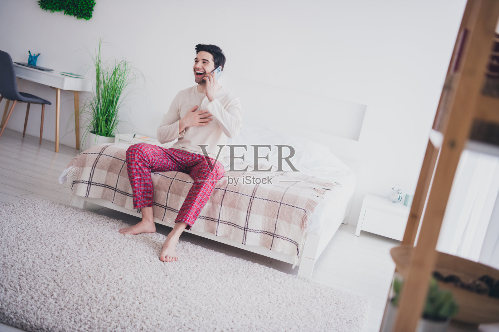 周末早晨，阳光明媚的室内，一个开朗的好男人在电话里笑着照片摄影图片