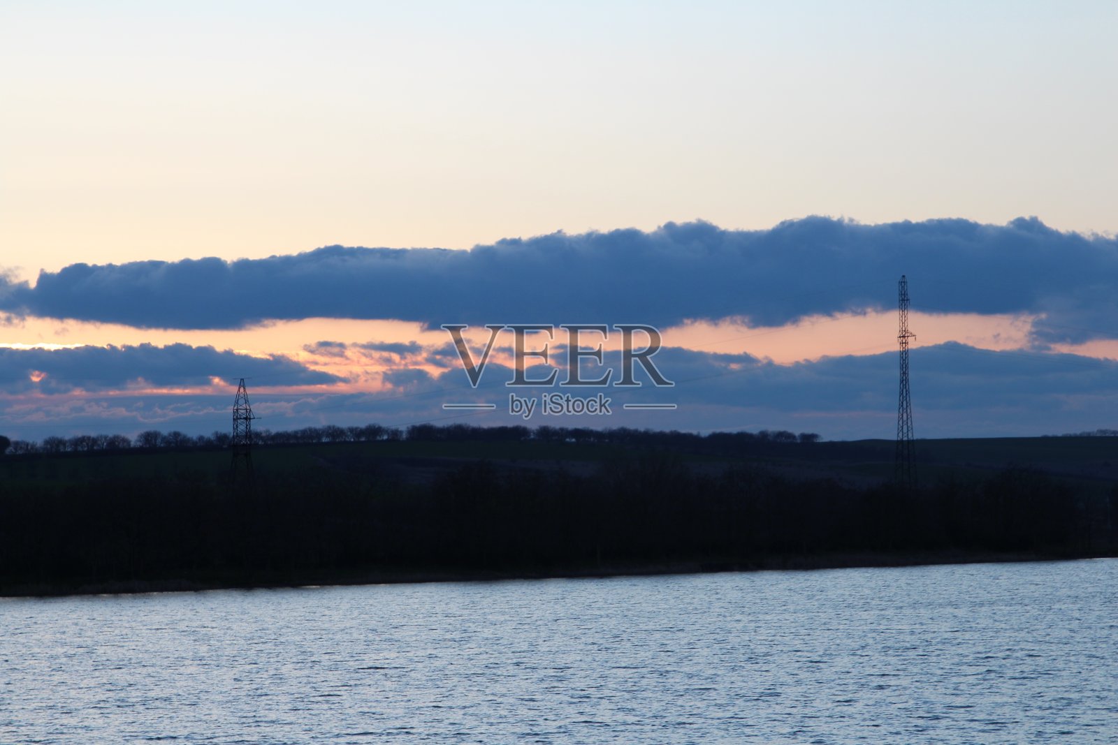 背景是一片有高塔和小山的水域照片摄影图片