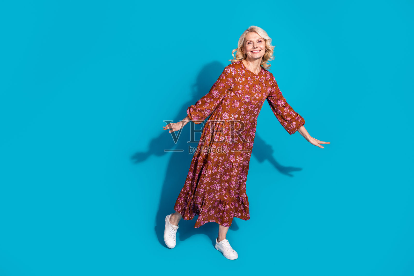 可爱可爱的女人穿着棕色的裙子，有乐趣的空白空间孤立的蓝色背景的全长照片照片摄影图片