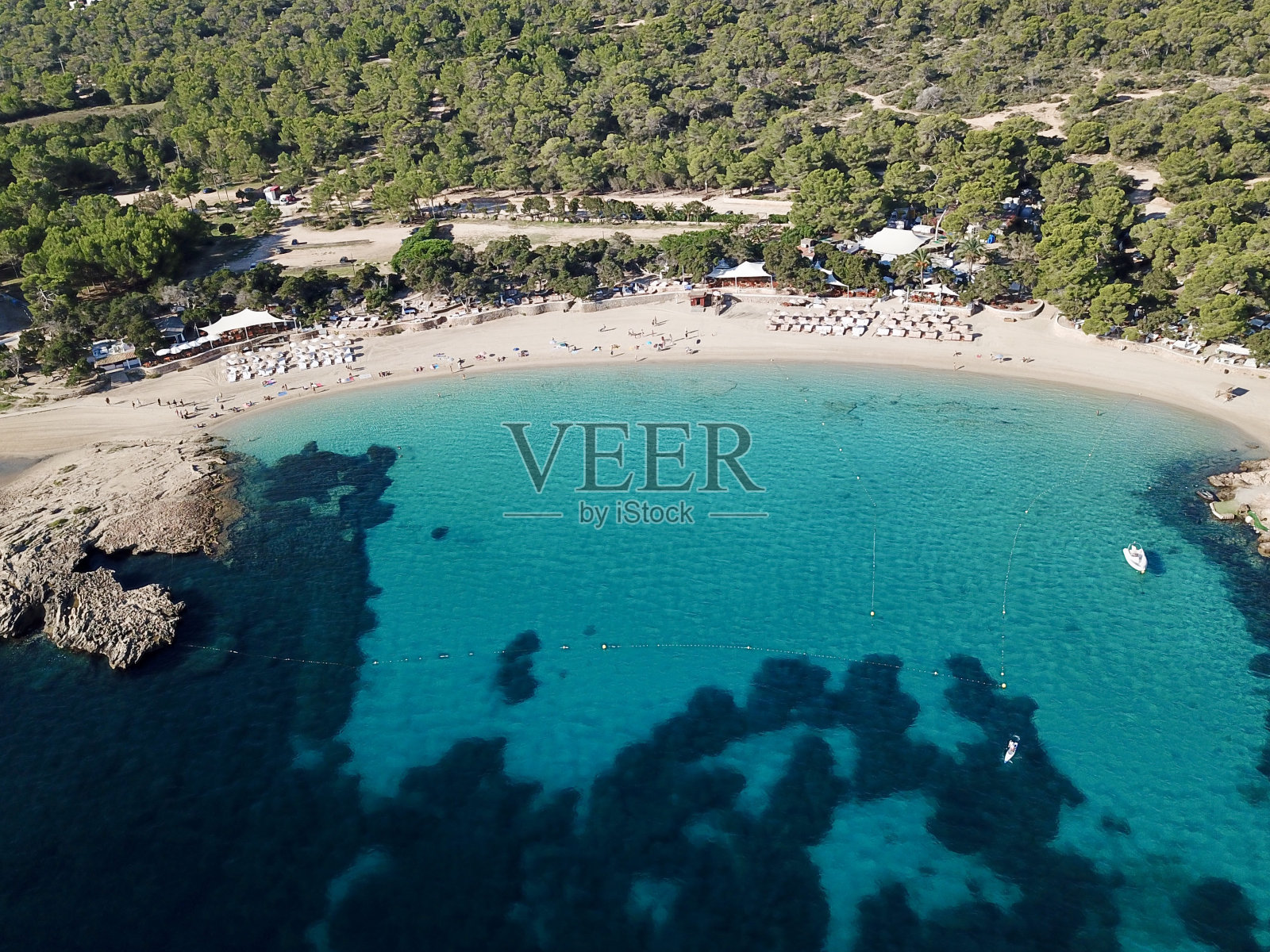 热带海滩的鸟瞰图，清澈碧蓝的海水与郁郁葱葱的绿色森林并排照片摄影图片