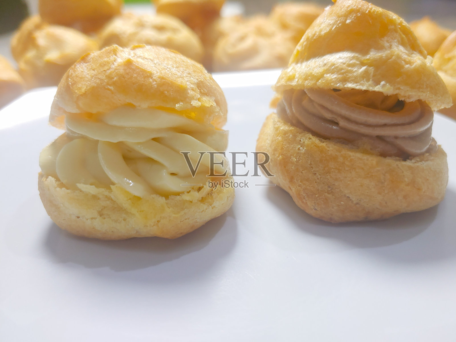 国企蛋糕也被称为泡芙糕点与巧克力和香草填充在白色盘子照片摄影图片