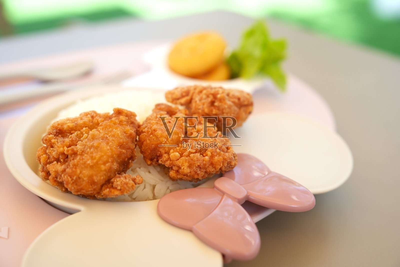 特写可爱的餐盘孩子在模糊的桌子背景与炸鸡，新鲜的开胃食品分开的部分，吃健康的食物。照片摄影图片