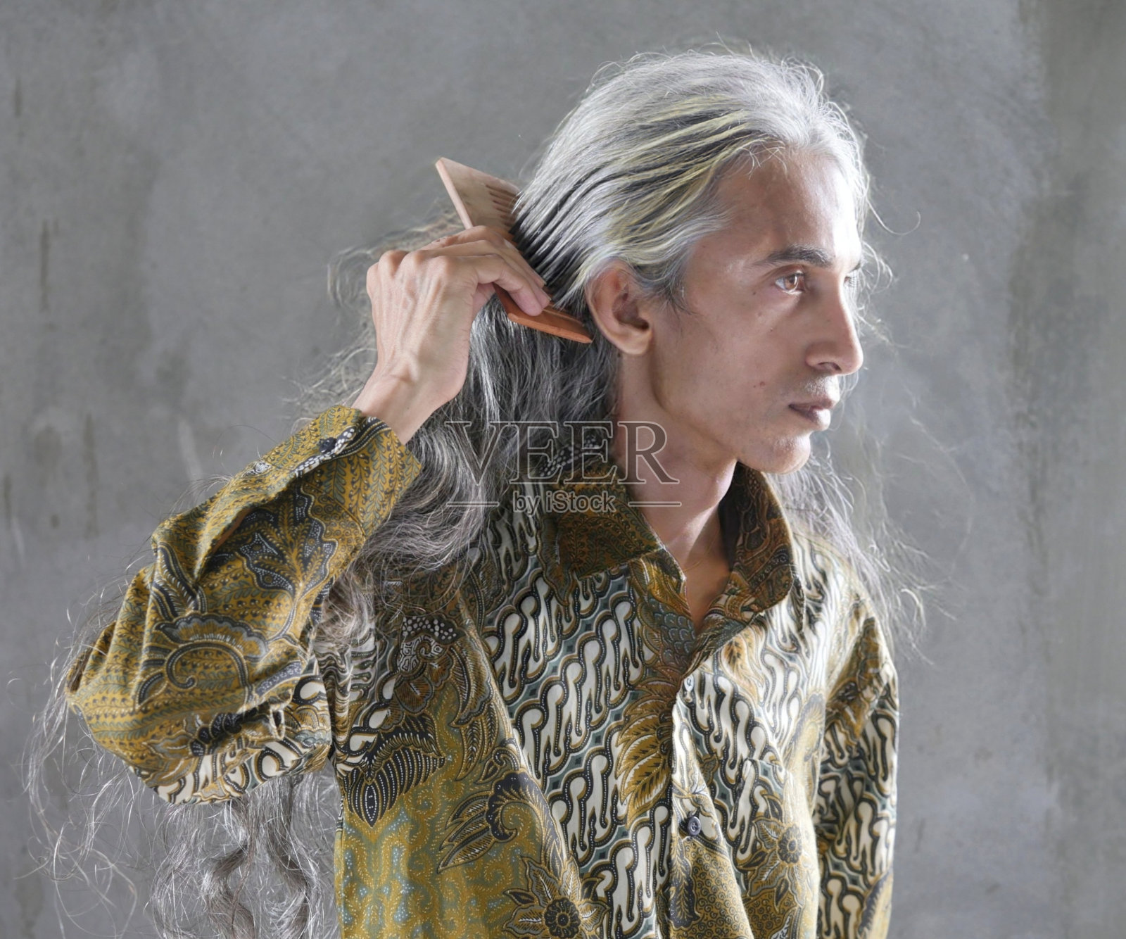 用木梳梳理白色长发的男人照片摄影图片