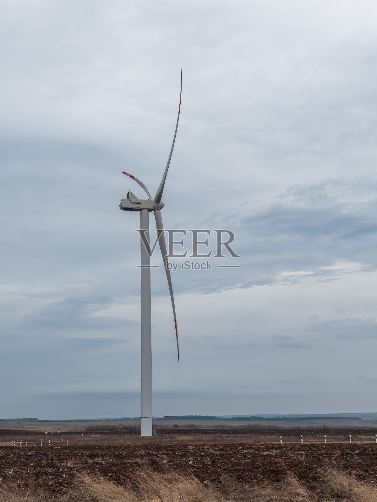 在一个美丽的背景上，一个风力涡轮机在特写中旋转照片摄影图片